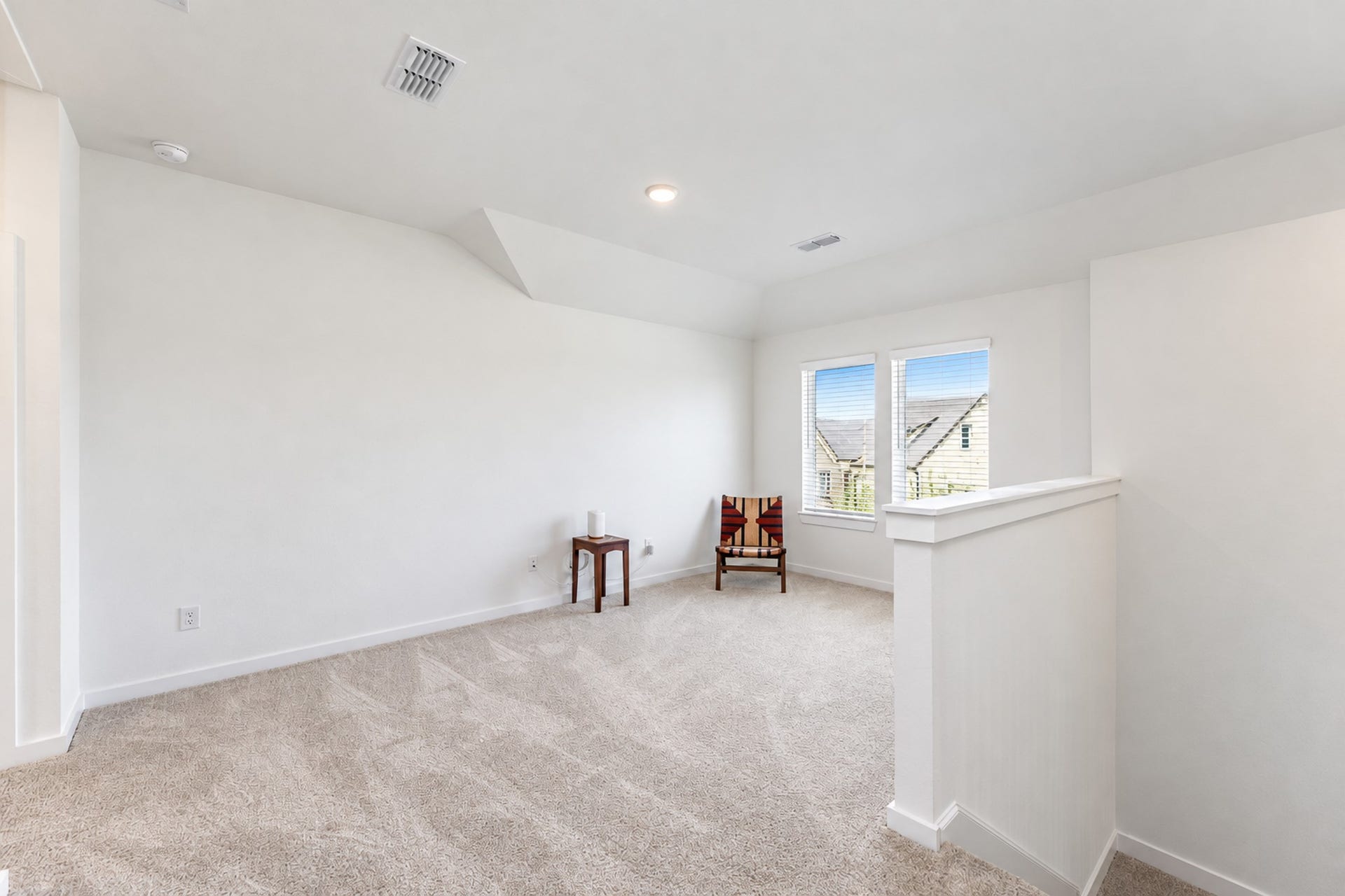 16922 Warm Glow Court, Hockley, TX 77447 Bright and inviting loft space with plush carpeting, perfect for a cozy reading nook or office area, featuring two large windows for ample natural light.