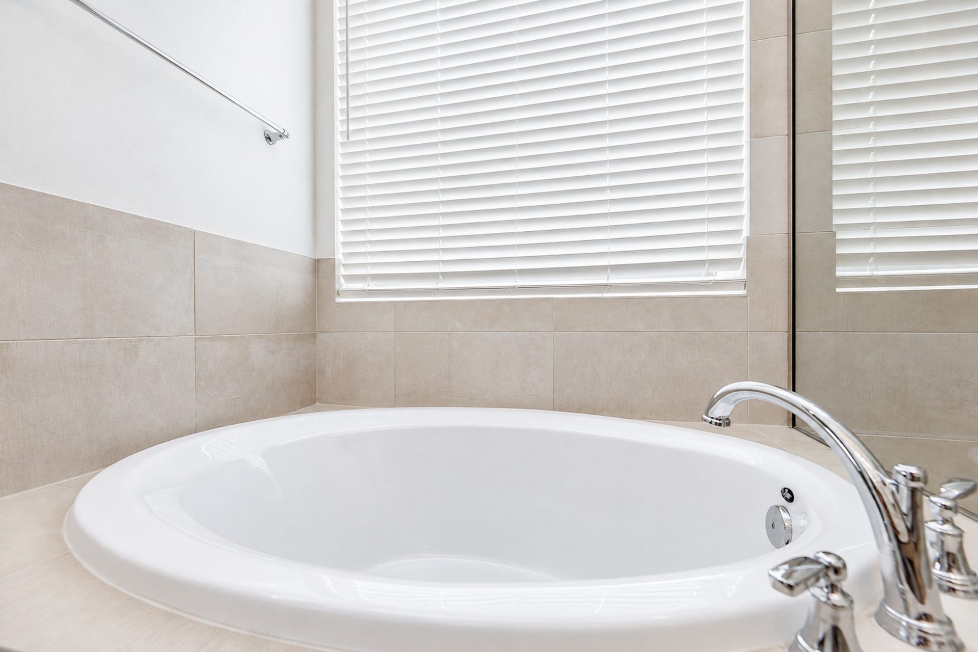 16922 Warm Glow Court, Hockley, TX 77447 Luxurious bathroom featuring a spacious soaking tub with elegant fixtures, complemented by soft neutral tiles and ample natural light.