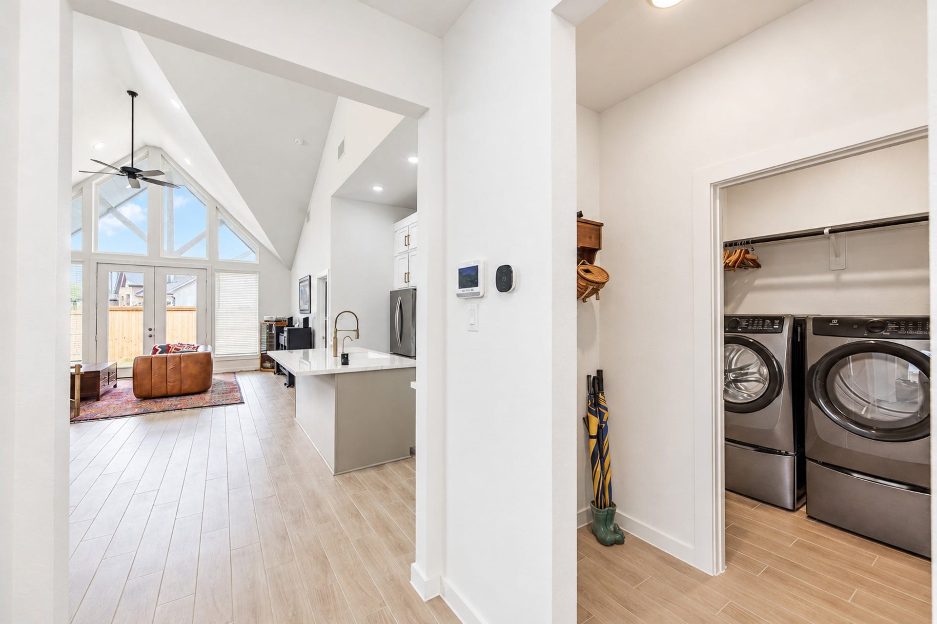 16922 Warm Glow Court, Hockley, TX 77447 Bright and open living space with soaring vaulted ceilings and large windows, complemented by a sleek kitchen and convenient adjacent laundry room.