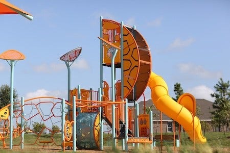 16922 Warm Glow Court, Hockley, TX 77447 Vibrant playground featuring a climbing structure and a spiral slide, perfect for family fun and outdoor activities.