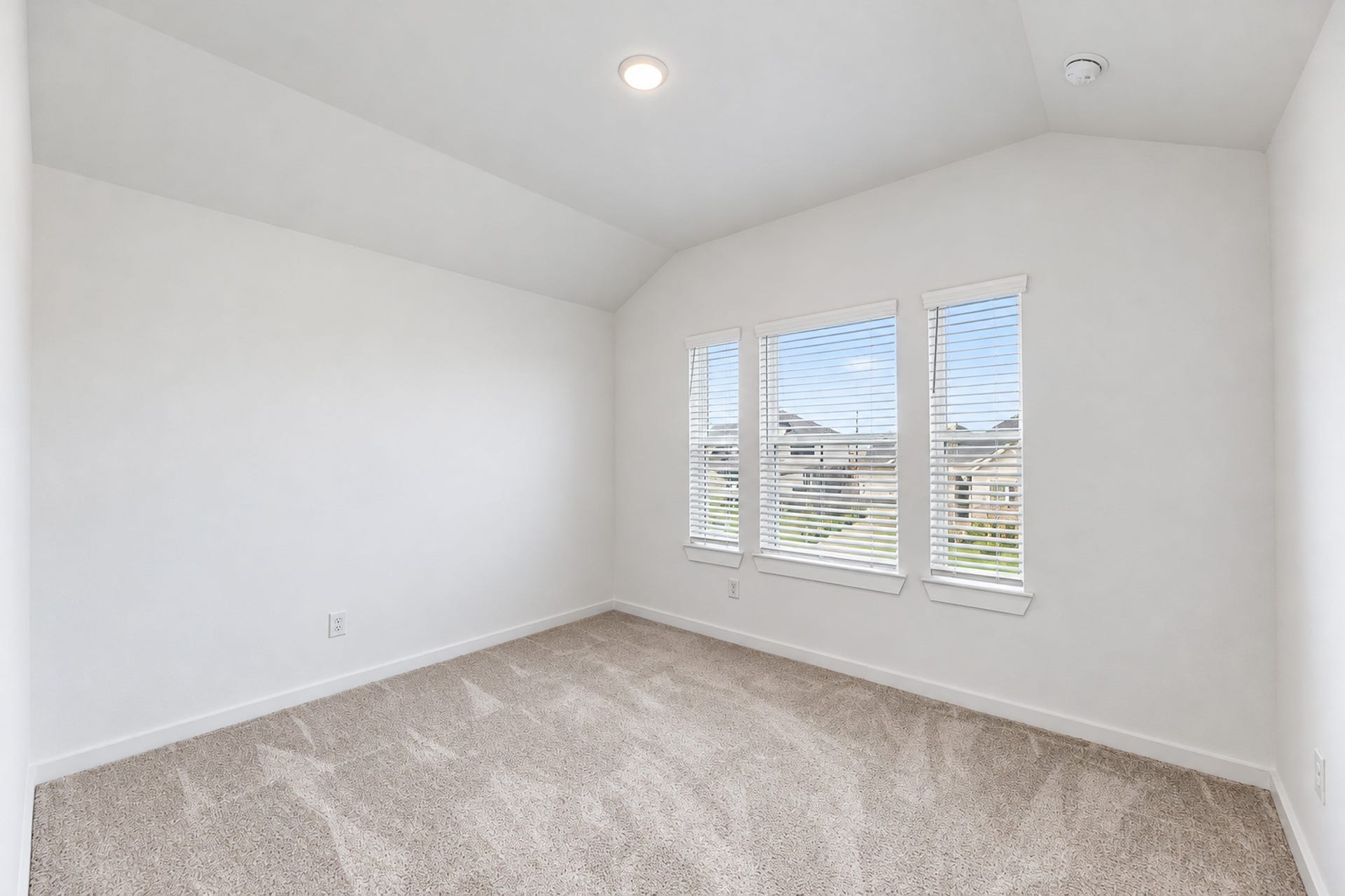 16922 Warm Glow Court, Hockley, TX 77447 Bright and airy bedroom with plush carpeting and large windows offering a scenic neighborhood view.