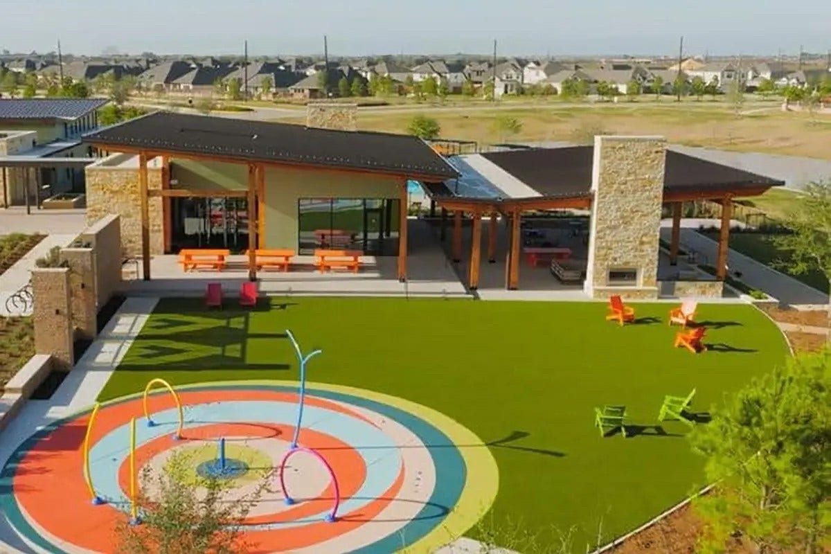 16922 Warm Glow Court, Hockley, TX 77447 Charming community center featuring a modern pavilion, vibrant splash pad, and inviting outdoor seating, perfect for family gatherings and relaxation.