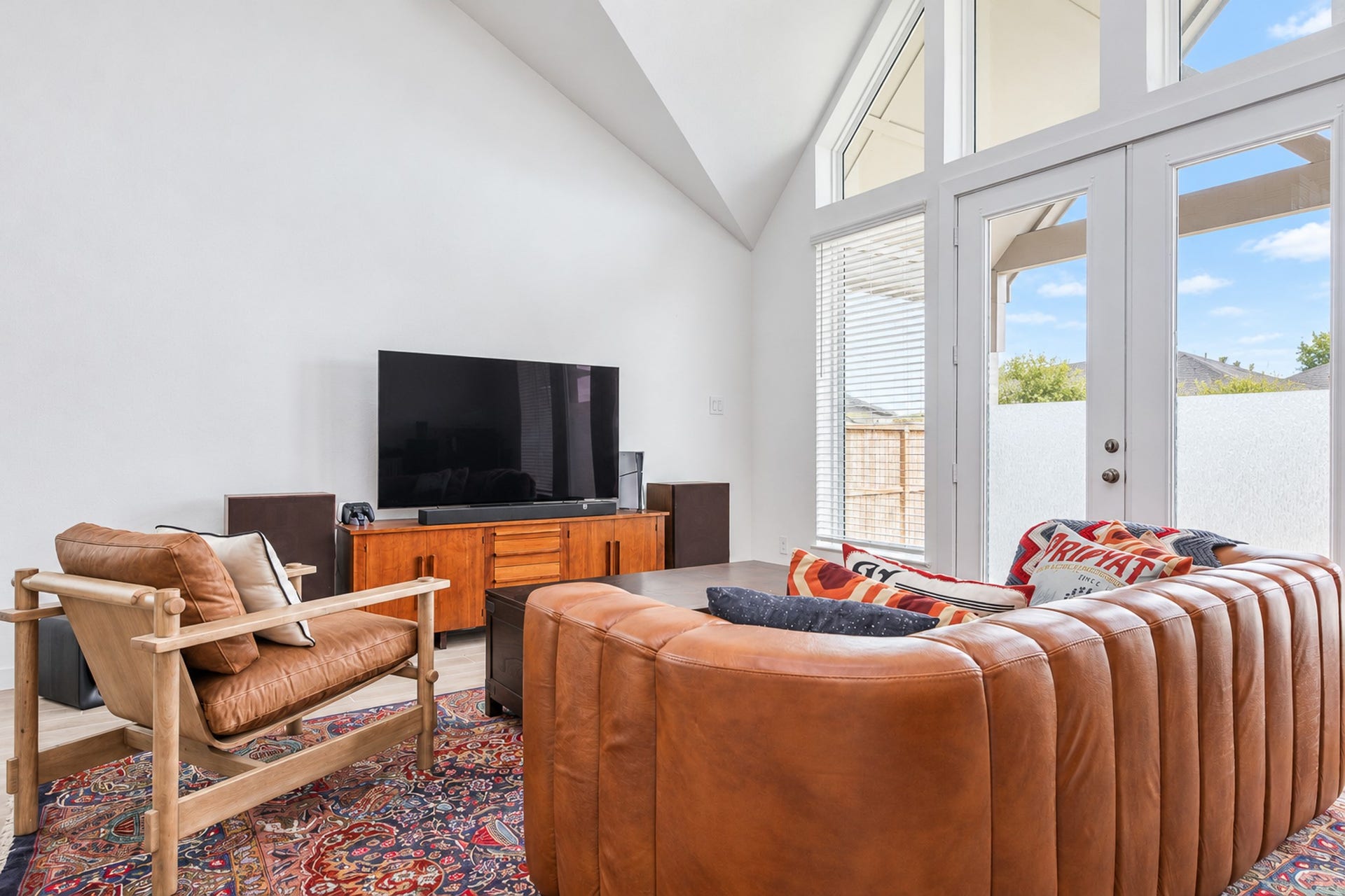 16922 Warm Glow Court, Hockley, TX 77447 Bright and inviting living room featuring high ceilings, expansive windows, and stylish leather seating, perfect for relaxation and entertainment.