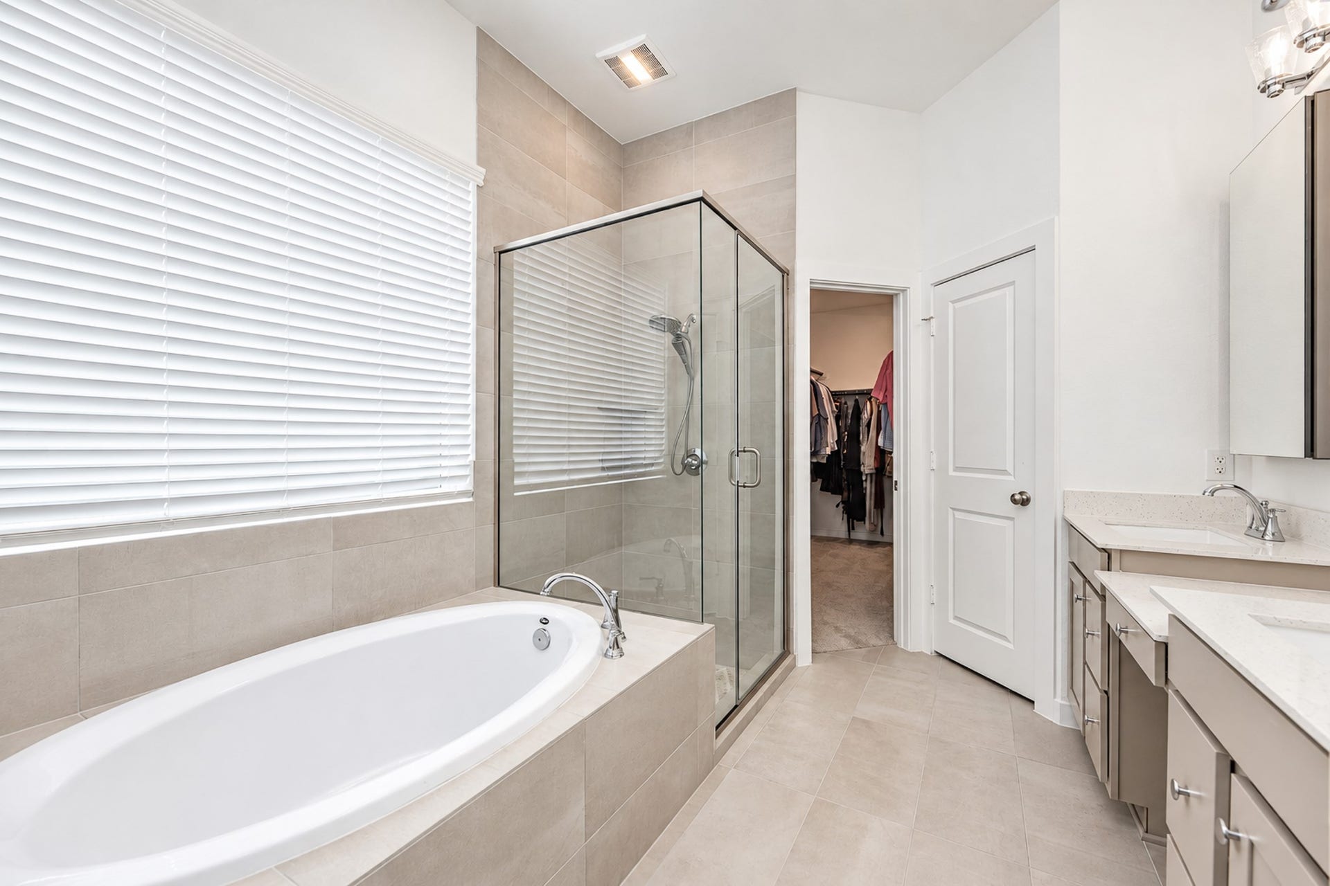 16922 Warm Glow Court, Hockley, TX 77447 Elegant bathroom featuring a spacious glass-enclosed shower, luxurious soaking tub, dual vanities, and access to a walk-in closet.