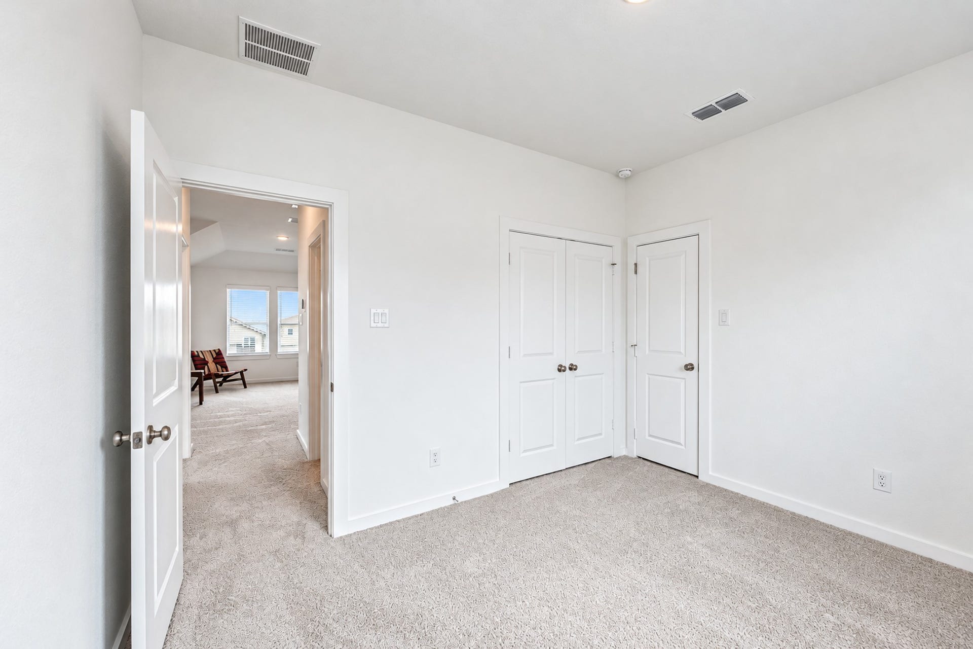 16922 Warm Glow Court, Hockley, TX 77447 Bright and inviting bedroom with plush carpeting, dual closets, and an adjoining space leading to a sunlit room.
