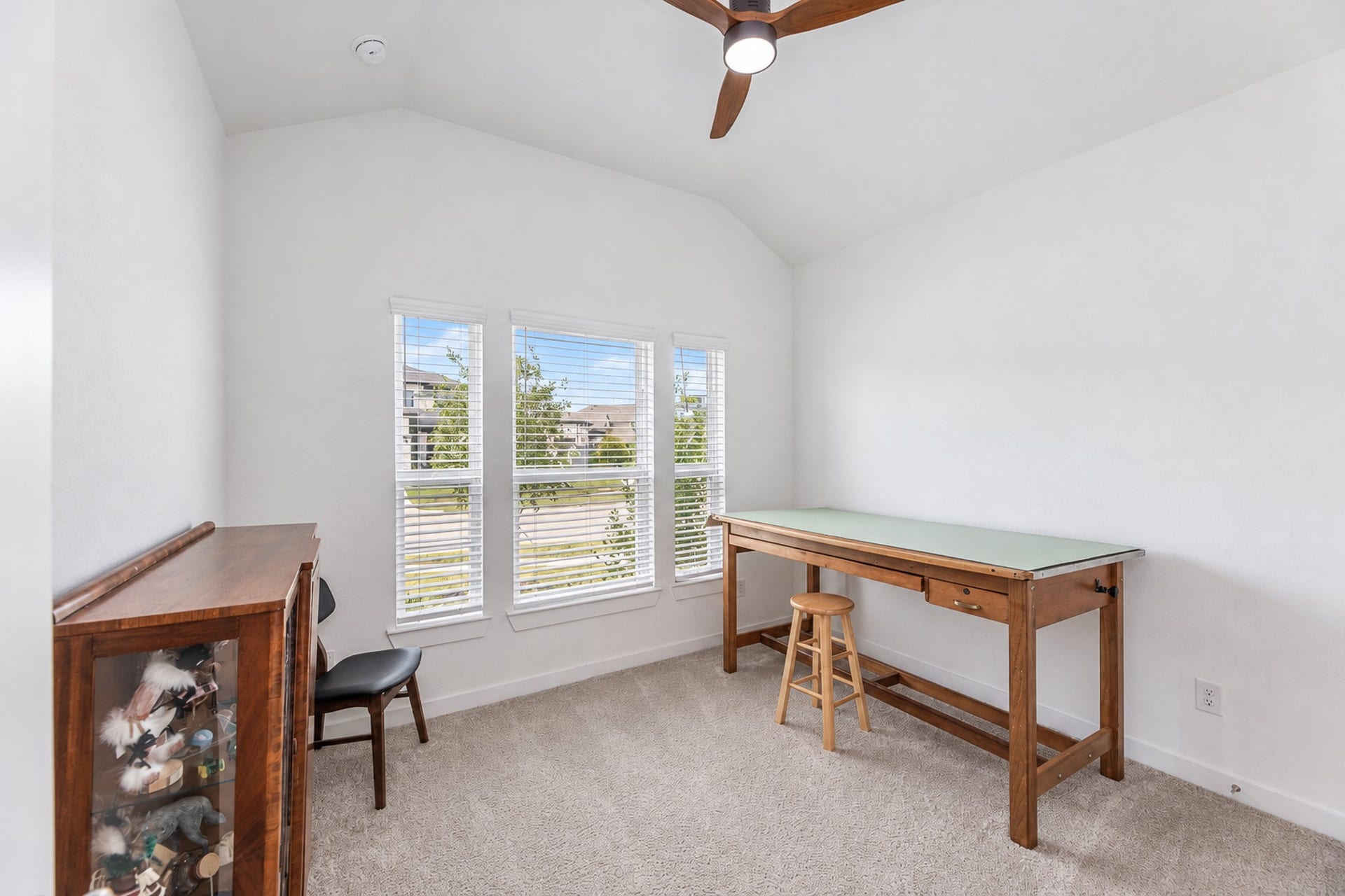 16922 Warm Glow Court, Hockley, TX 77447 Bright and versatile room with high ceilings, large windows, and neutral carpeting, perfect for a home office or creative space.