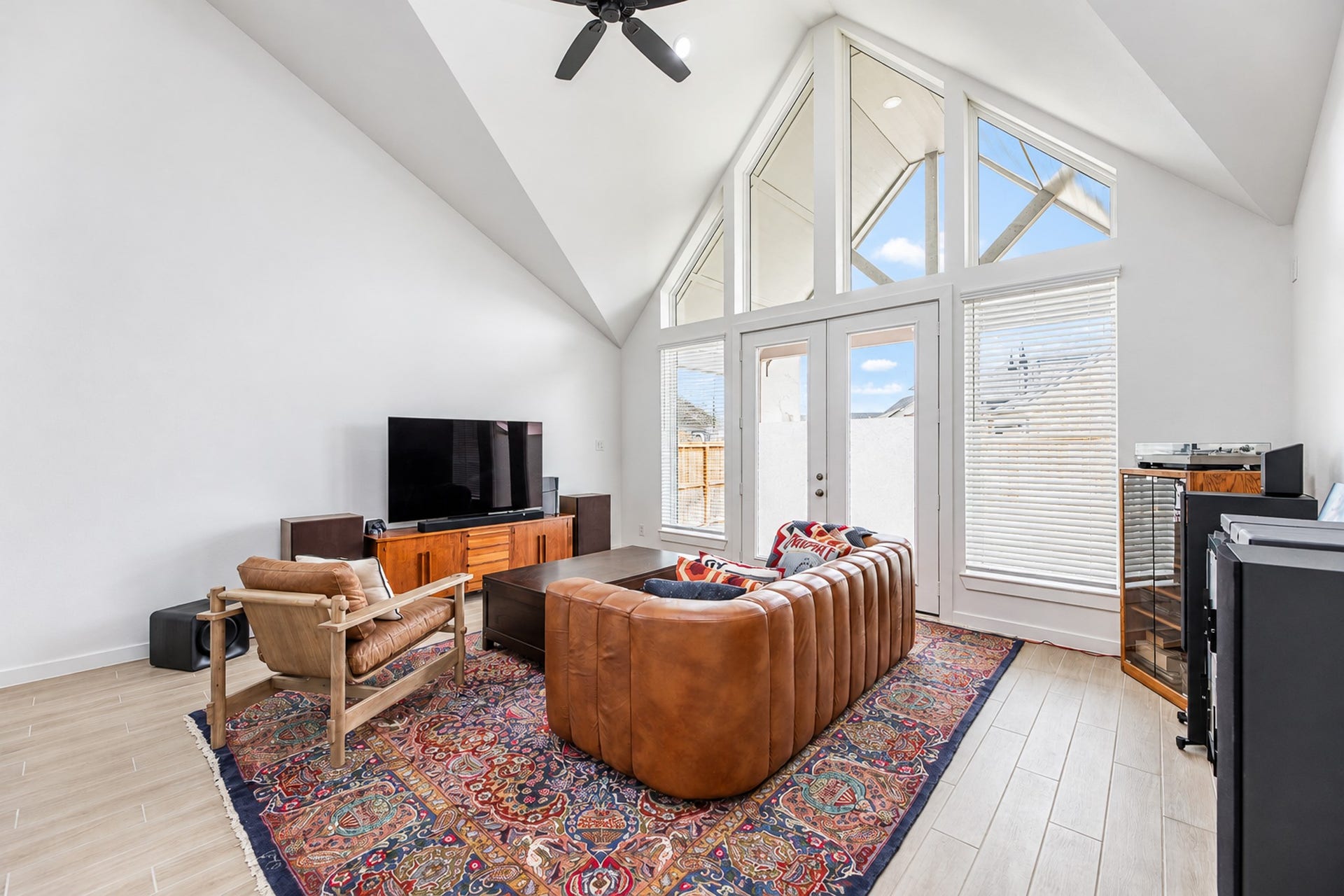 16922 Warm Glow Court, Hockley, TX 77447 Bright and inviting living space featuring vaulted ceilings, expansive windows, and modern furnishings, creating a perfect blend of comfort and style.