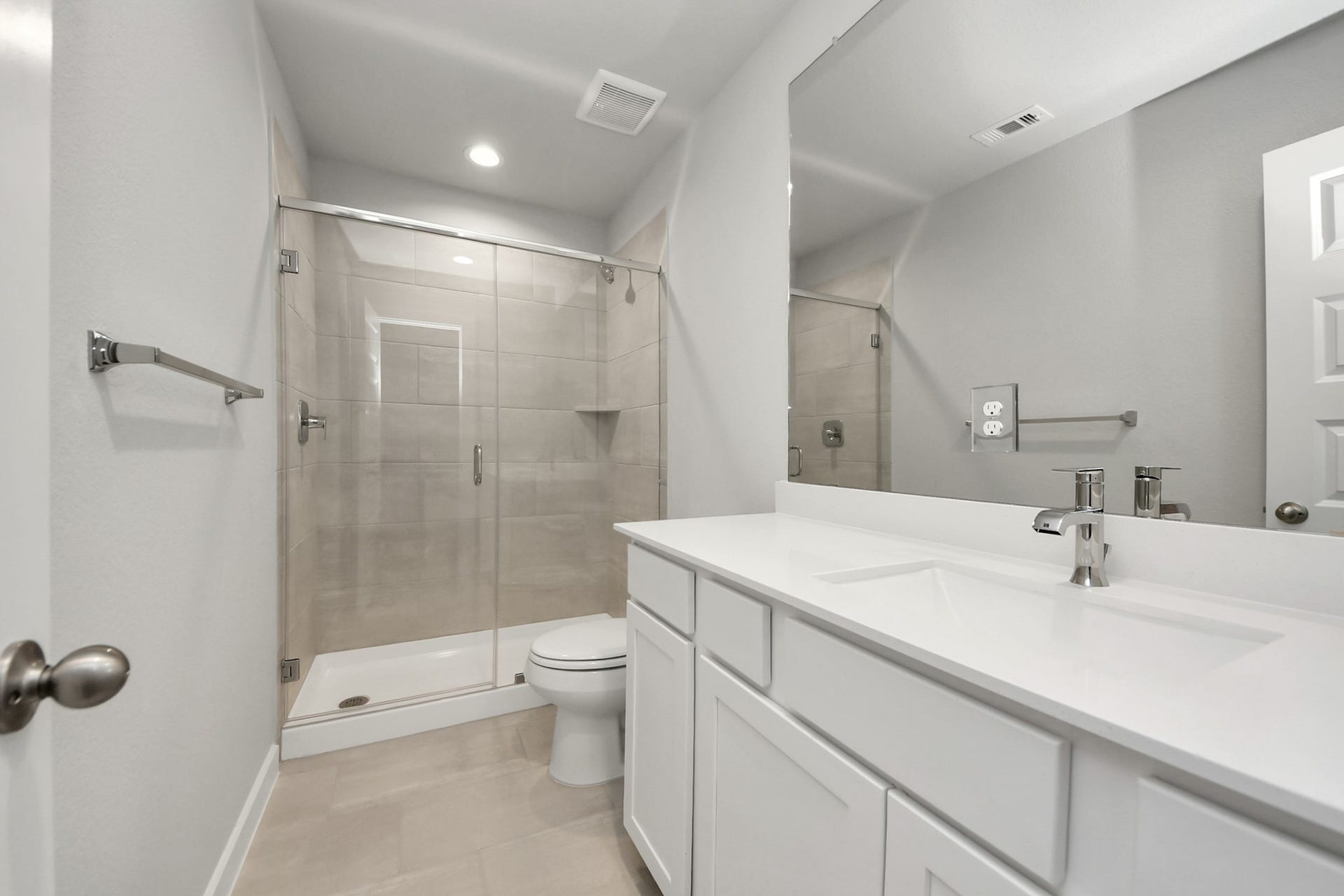 11103 Tulip Ridge Trail, Houston, TX 77044 Secondary bath features tile flooring, walk-in shower with tile surround, light stained wood cabinets, beautiful light countertop. Sample photo of completed home with similar floor plan. Actual colors and selections may vary.