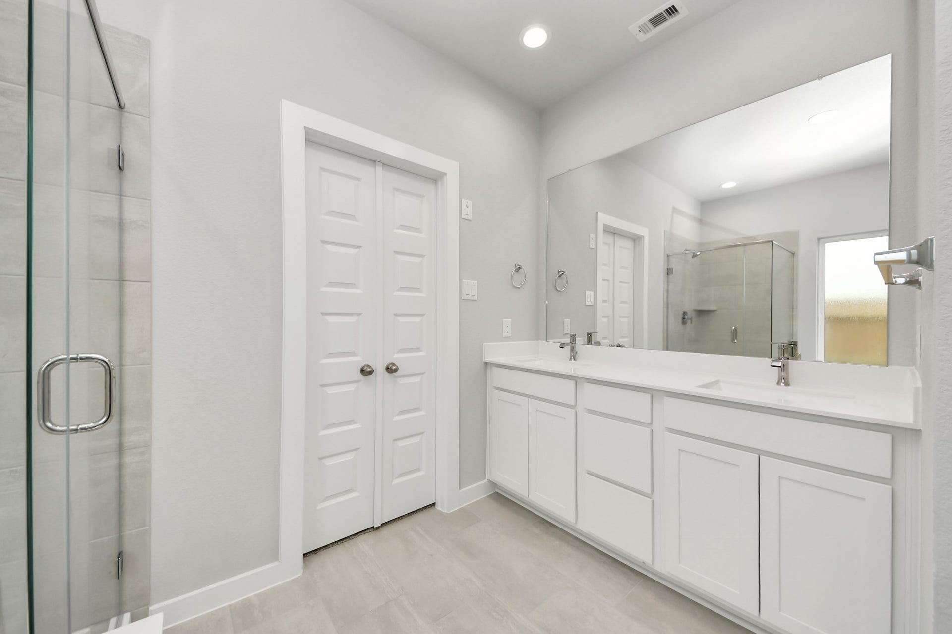 11103 Tulip Ridge Trail, Houston, TX 77044 Elevate your daily routine at the elegant vanity, now equipped with double sinks, light countertops, modern hardware, and beautiful recessed lights. Sample photo of completed home with similar floor plan. Actual colors and selections may vary.