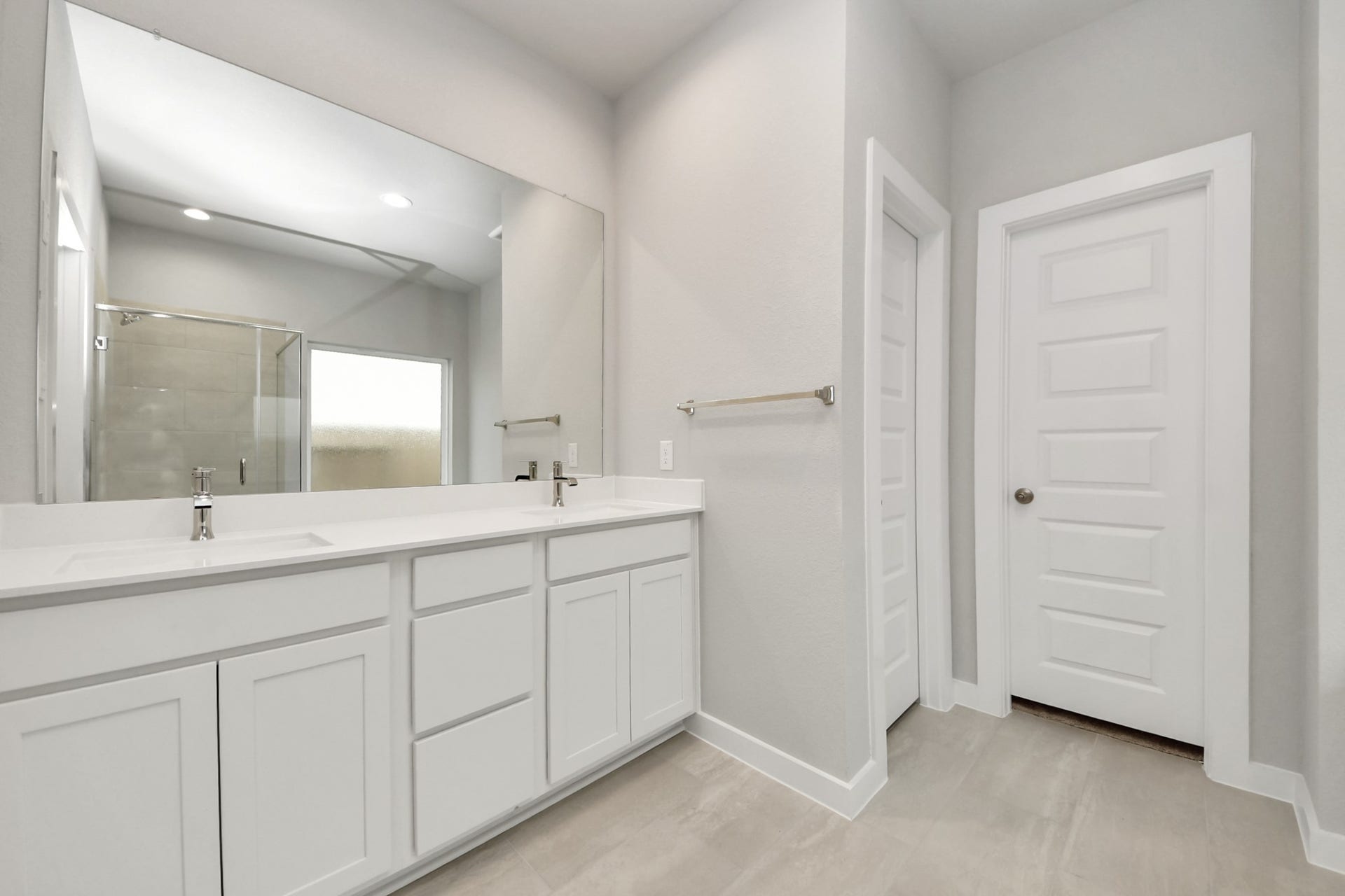11103 Tulip Ridge Trail, Houston, TX 77044 Escape to a spa-like oasis in this primary bathroom. Enjoy a walk-in shower with tile surround, a separate garden tub with custom detailing, and an elegant vanity featuring light countertops, modern hardware, and beautiful recessed lights. Experience luxury and relaxation in every detail. Sample photo of completed home with similar floor plan. Actual colors and selections may vary.