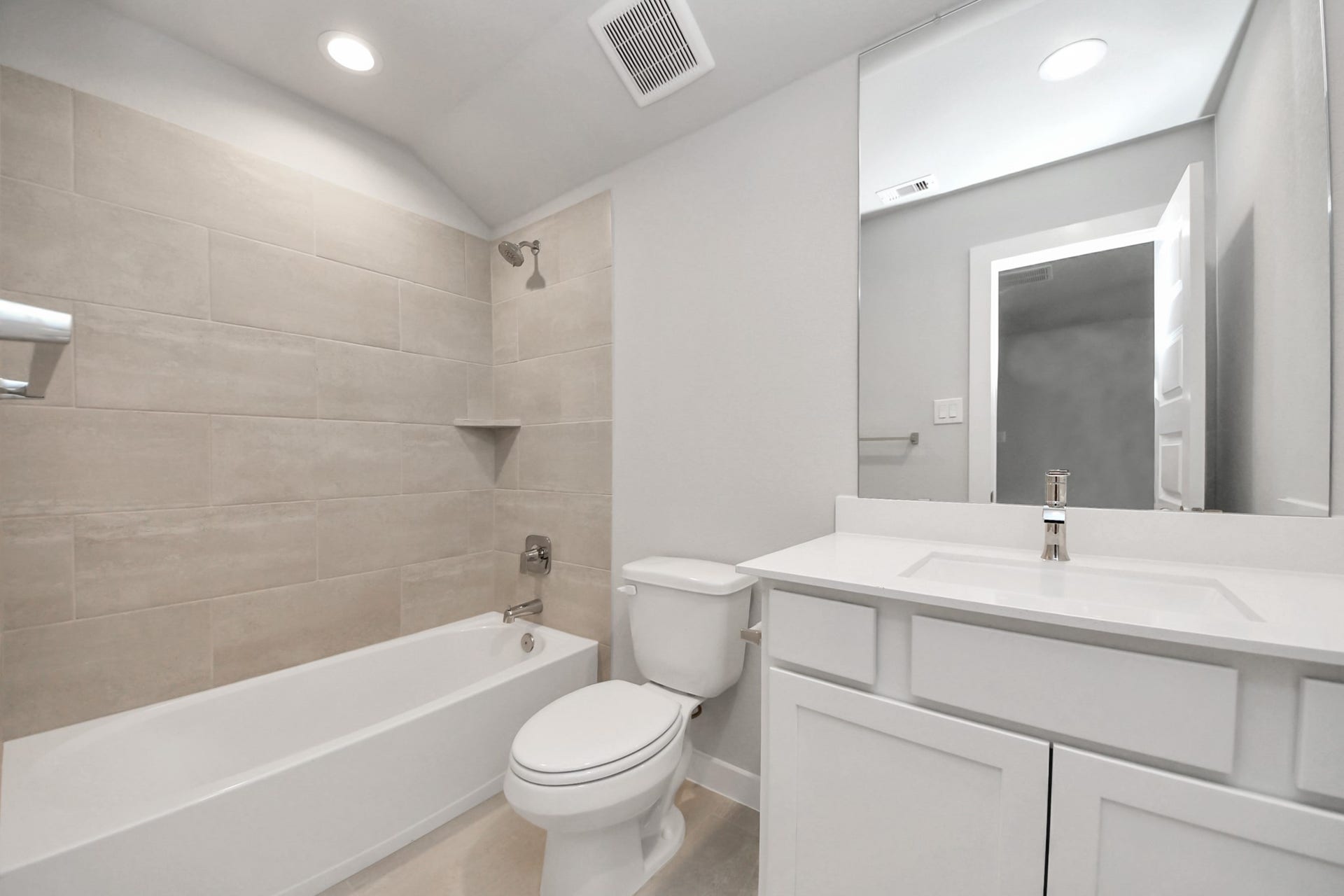 11103 Tulip Ridge Trail, Houston, TX 77044 Secondary bath features tile flooring, bath/shower combo with tile surround, light stained wood cabinets, beautiful light countertop. Sample photo of completed home with similar floor plan. Actual colors and selections may vary.
