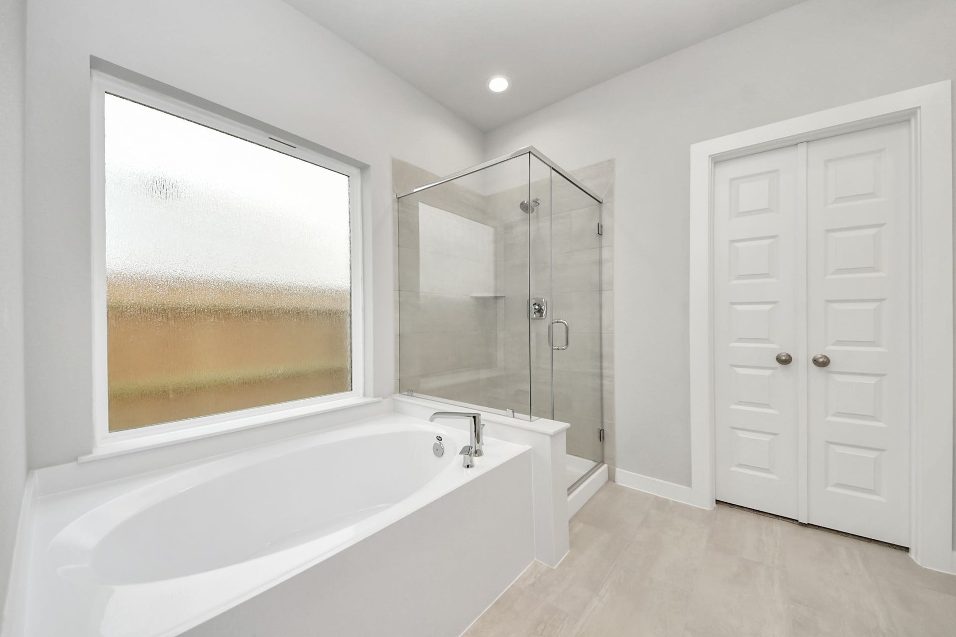 11103 Tulip Ridge Trail, Houston, TX 77044 Indulge in a spa-like retreat within the confines of this primary bathroom. Delight in a spacious walk-in shower enveloped in stylish tile surround and unwind in a separate garden tub adorned with custom detailing. Sample photo of completed home with similar floor plan. Actual colors and selections may vary.