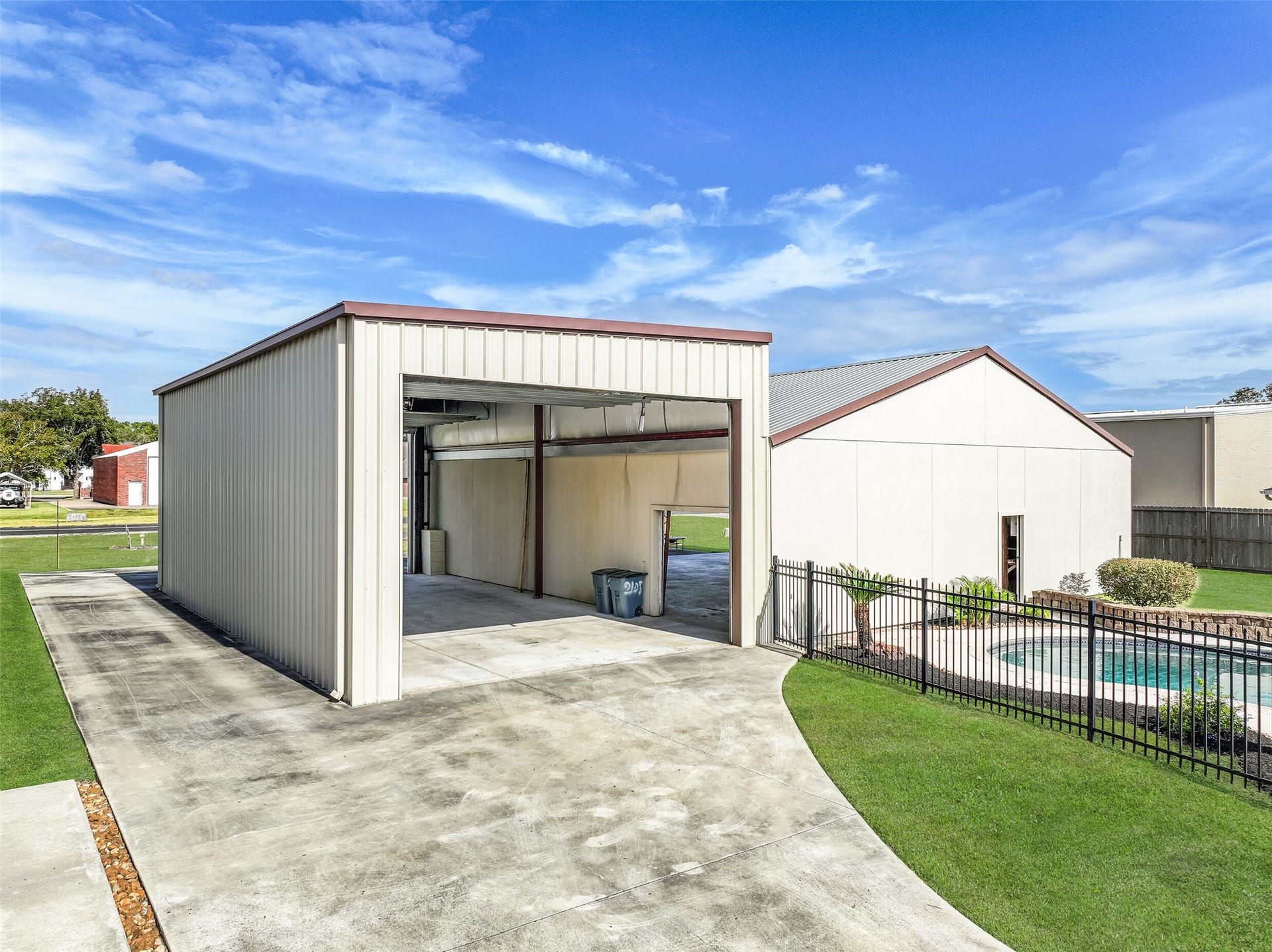 The adjoining 24' x 47' RV garage features a 17' flat roof height, front and rear overhead doors, and a concrete driveway providing easy access from the street. Positioned alongside the private airplane hangar, this versatile space offers exceptional storage possibilities for RVs, recreational vehicles, and equipment.