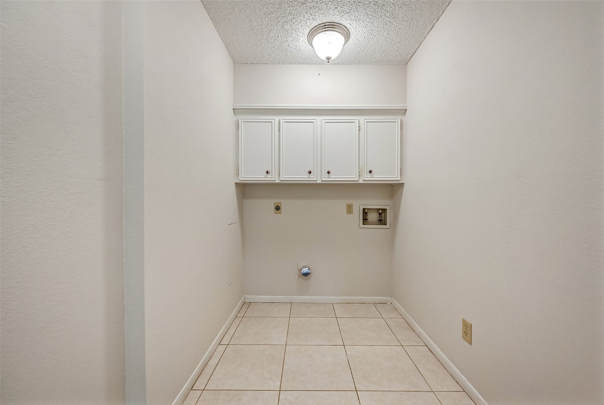 The dedicated first-floor laundry room offers washer & dryer connections, tiled flooring and overhead cabinetry for storing detergents and household essentials. Conveniently positioned near the secondary bedrooms, this practical space keeps laundry tasks separate from the main living areas.