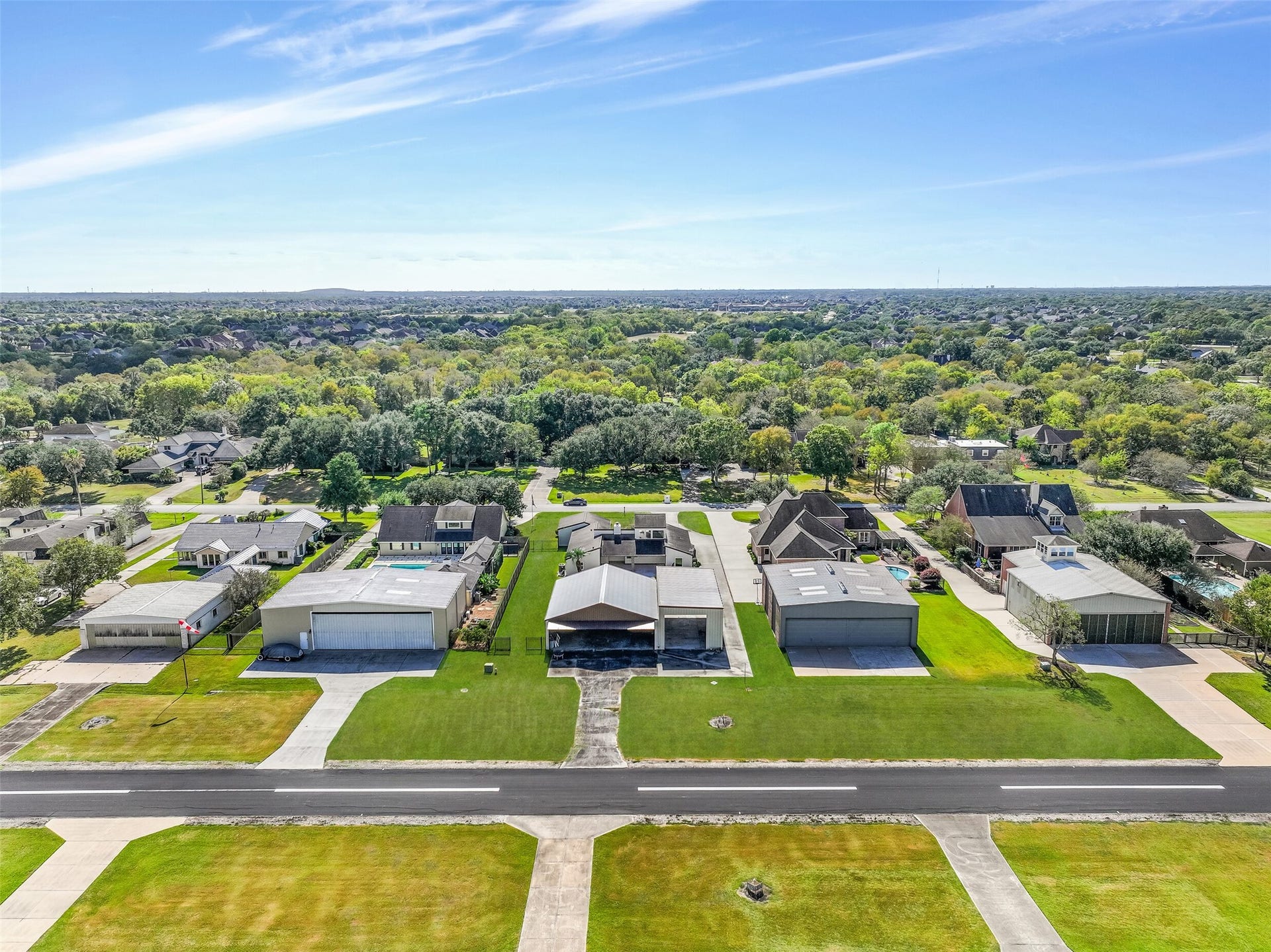 A runway-side aerial highlights the private hangar & adjoining RV garage with paved taxiway access to Polly Ranch Airport (7XS0). The 3,070' asphalt runway stretches across the foreground, with neighboring aviation properties illustrating the community's distinctive fly-in lifestyle.