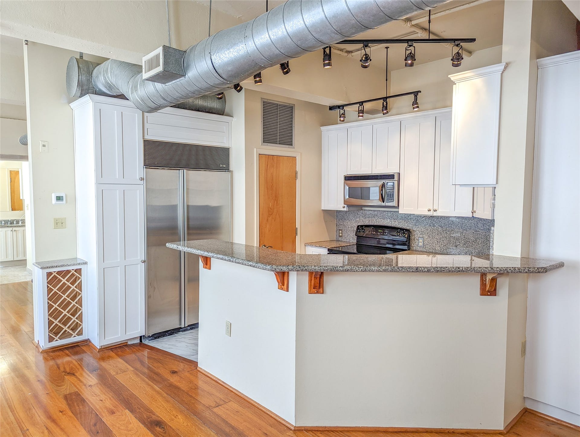 Modern kitchen opens to both dining/living rooms