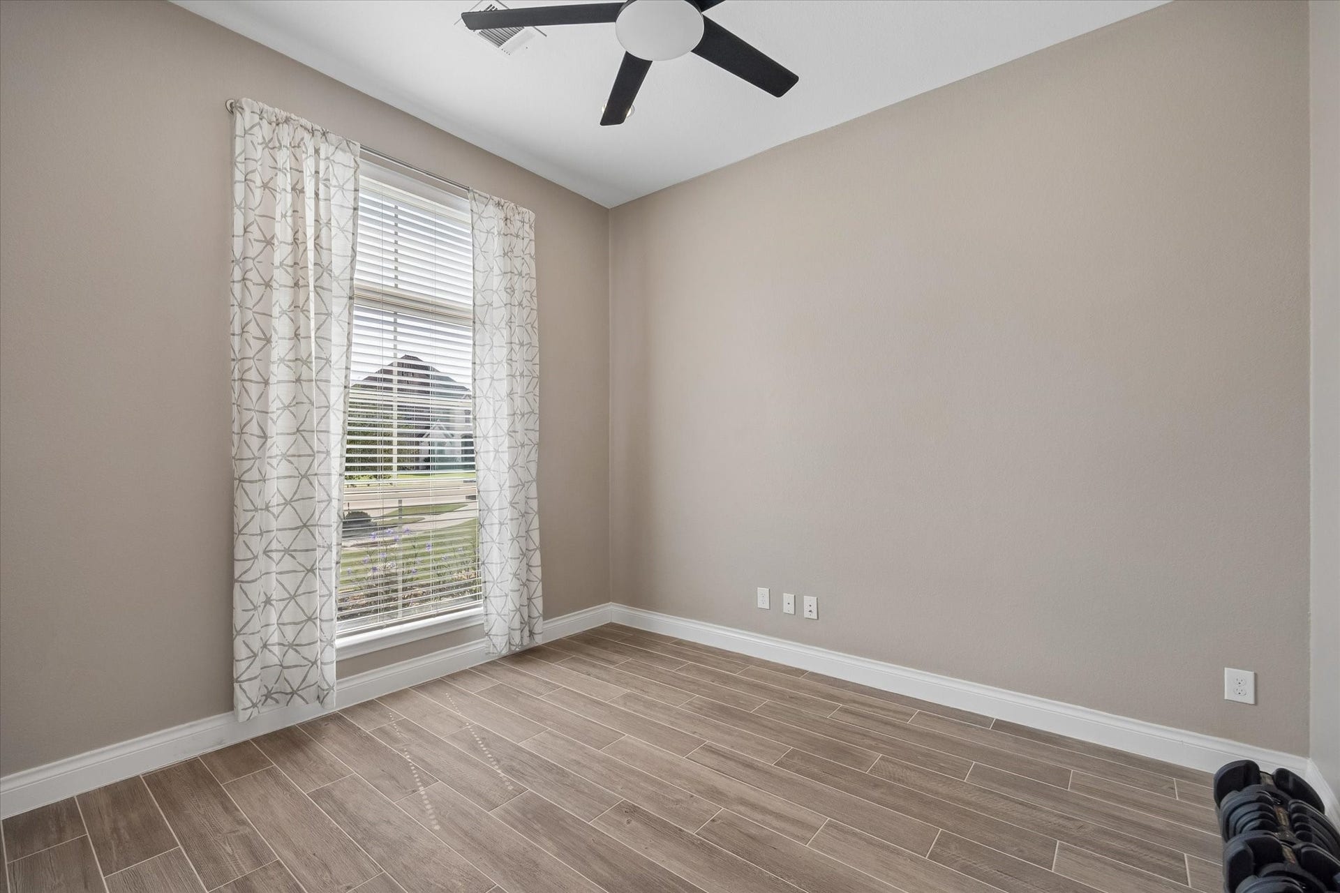 The office space  offers a large window looking out the front of the home. The office is private with the double French doors.