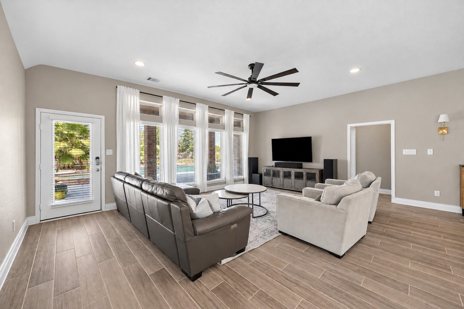 Open living room boasts wood look tile perfect for entry from the pool, pets, children, or just daily living!