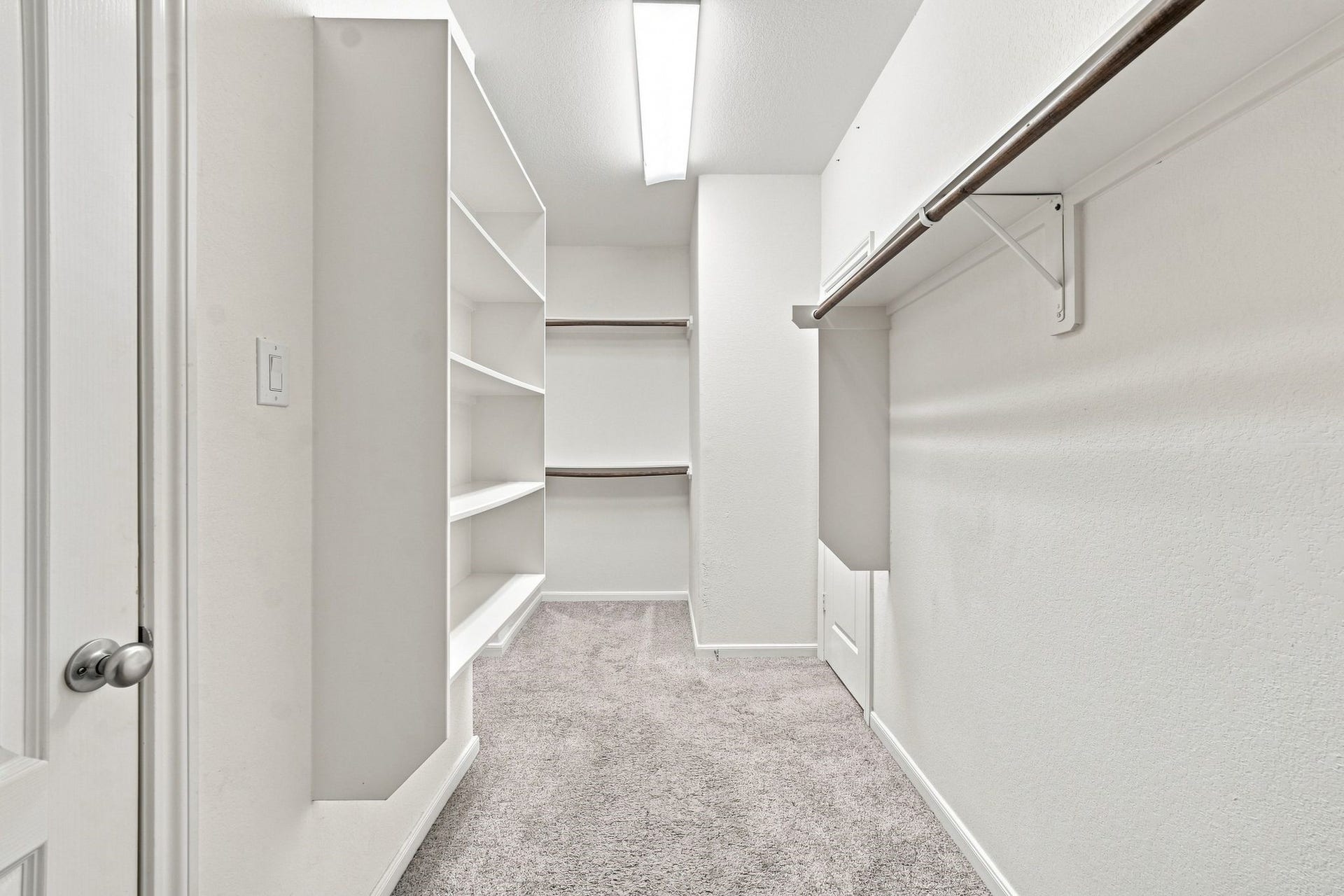 Spacious walk-in closet featuring ample shelving and hanging space, perfect for organizing your wardrobe.