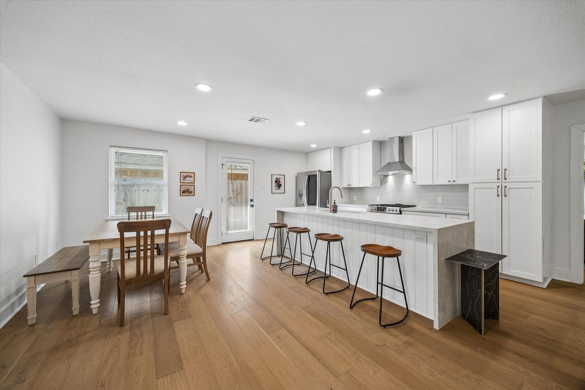 Everyday living feels effortless with the kitchen and breakfast area brought together in one open space. A wall of cabinetry provides impressive storage while a glass door offers direct access outdoors.