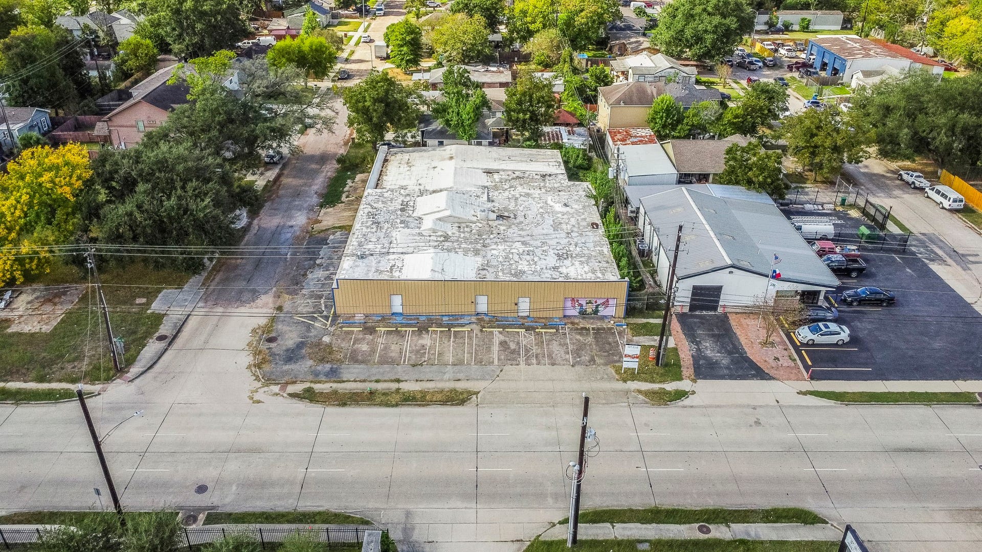 1018 Shaver Street, Pasadena, TX 77506 Front aerial view of the property showcasing its wide street frontage, multiple parking spaces, and placement within a well-established neighborhood.