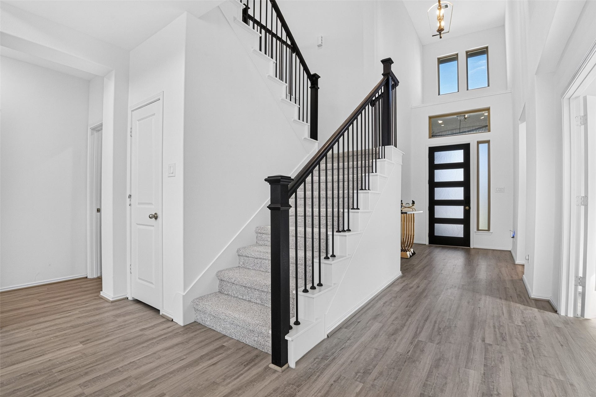1315 Munson Valley Road, Richmond, TX 77406 Beautiful carpeted staircase accented by black iron balusters and dark wood handrails.