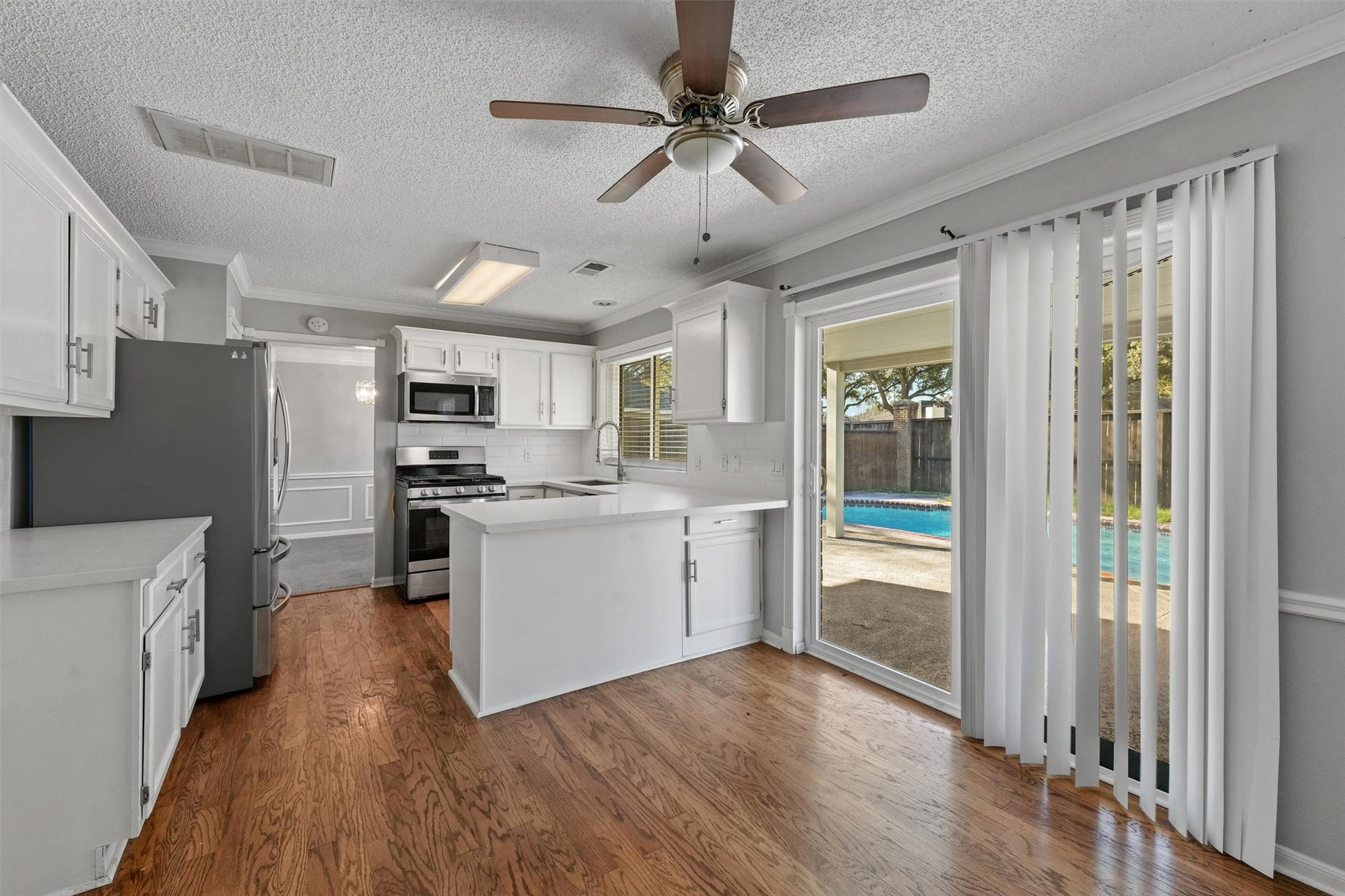 Indulge in the art of culinary creation in this spacious kitchen, adorned with pristine white cabinets, offering both functionality and timeless elegance. Your culinary masterpiece begins here