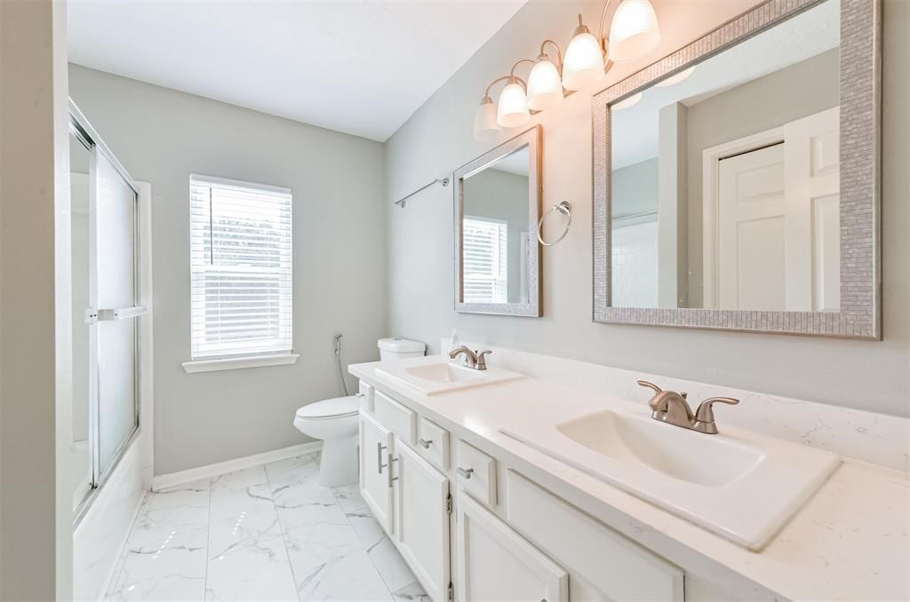 Double the convenience: This stylish secondary bathroom boasts dual sinks, offering a touch of luxury and functionality for your daily routine