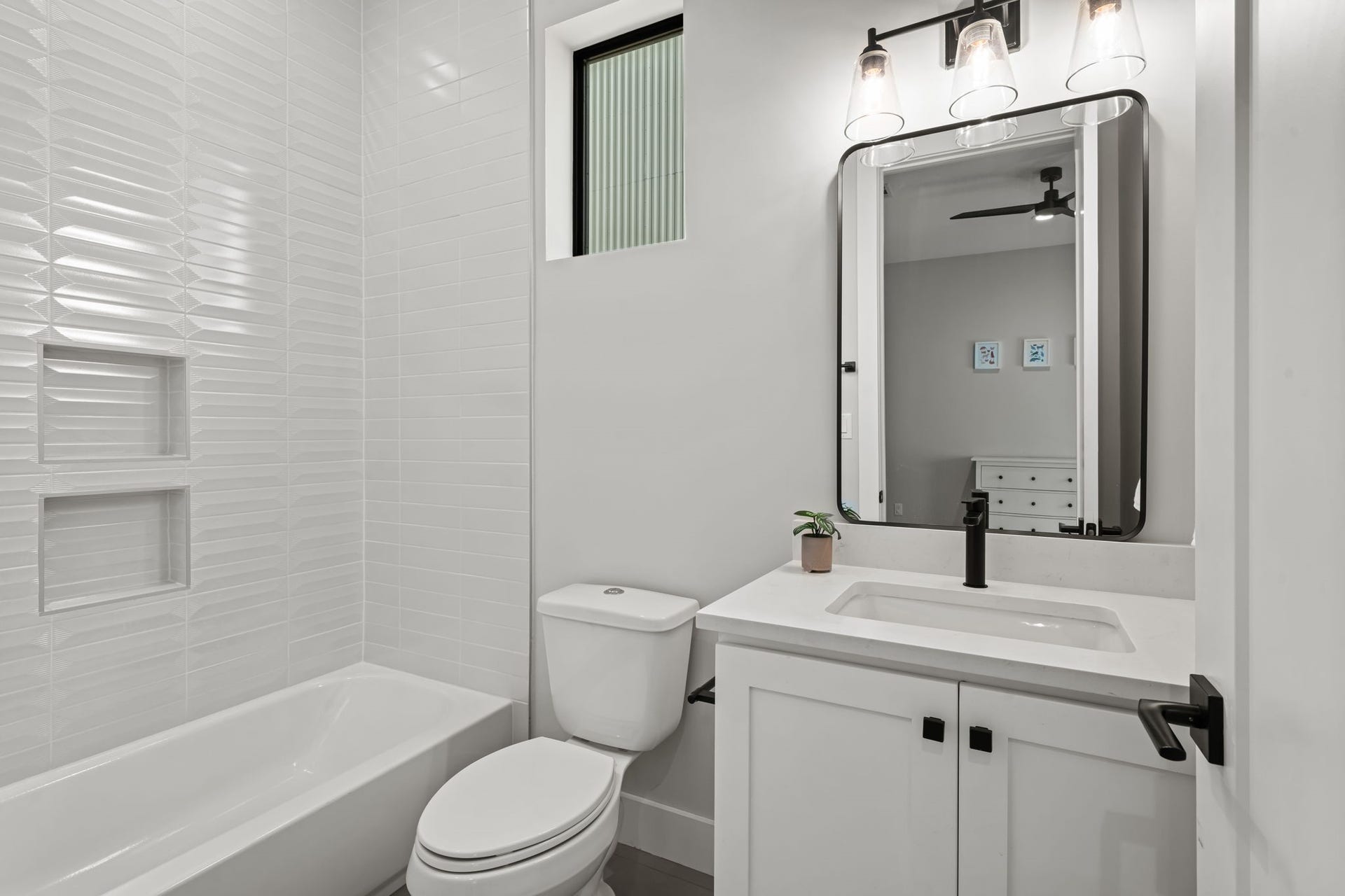 733 E 10th 1/2 Street, Houston, TX 77008 The adjoining bath is finished with a bright vanity, quartz counter, and contemporary fixtures. A tub-and-shower combination adds flexibility for guests or household members.
