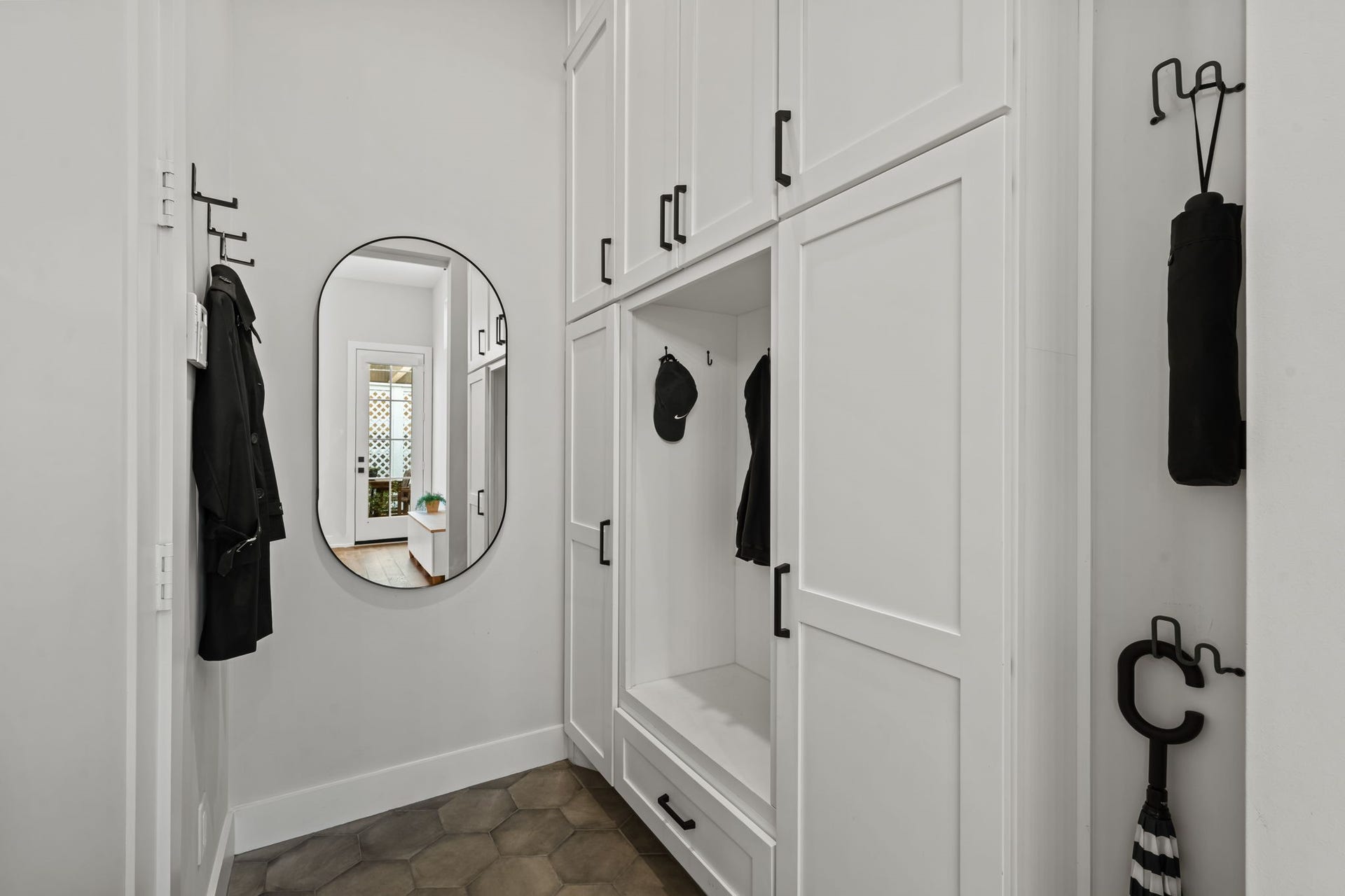 733 E 10th 1/2 Street, Houston, TX 77008 The stylish powder bath introduces bold contrast through its dark vanity, round mirror, and modern fixtures. Thoughtful finishes give this convenient first-floor space a memorable character.
