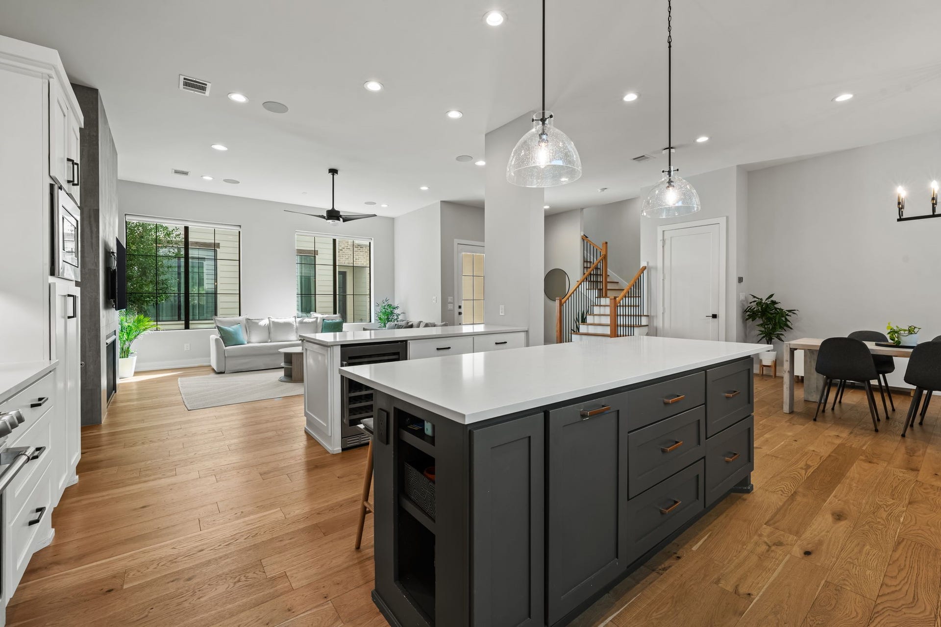 733 E 10th 1/2 Street, Houston, TX 77008 A broad view reveals the kitchen's double-island configuration and seamless connection to the living areas. Contrasting cabinetry defines the preparation zone while preserving an open, sociable layout.