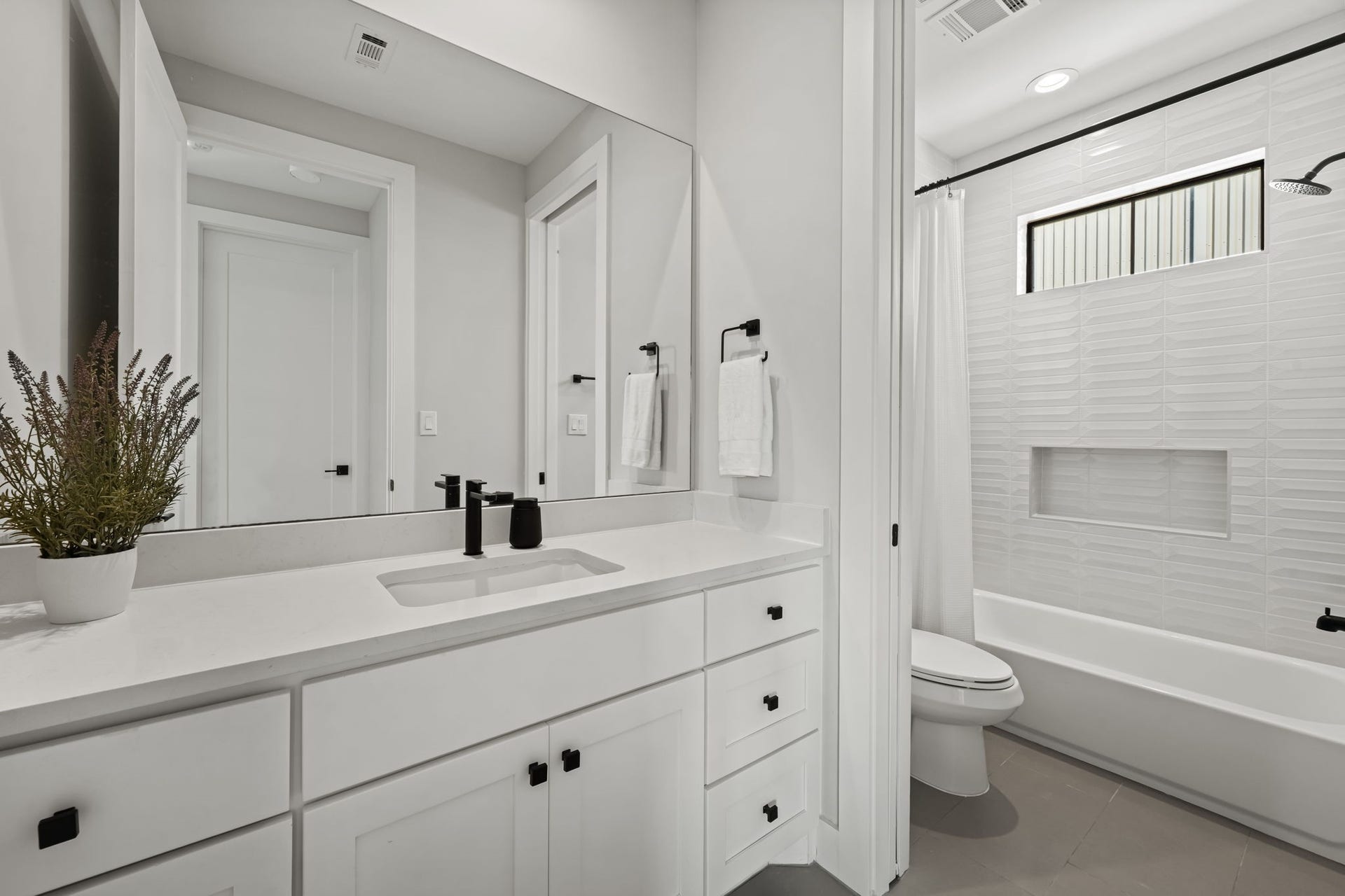 733 E 10th 1/2 Street, Houston, TX 77008 A bright third-floor bath serves the adjacent bedroom and entertainment area. Quartz counters, a spacious vanity, and a tub-and-shower combination offer polished functionality.