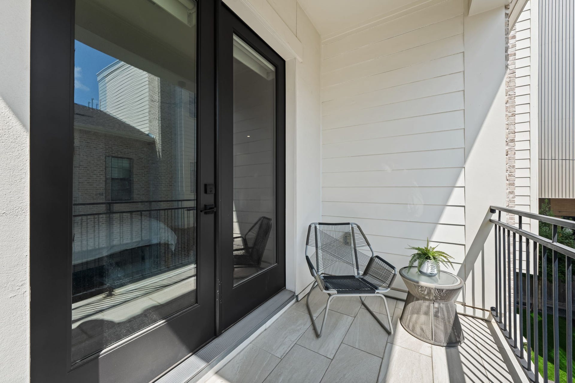 733 E 10th 1/2 Street, Houston, TX 77008 Direct balcony access extends the primary bedroom with a private open-air escape. Tile flooring and metal railings create a polished, low-maintenance setting for fresh air and quiet moments.
