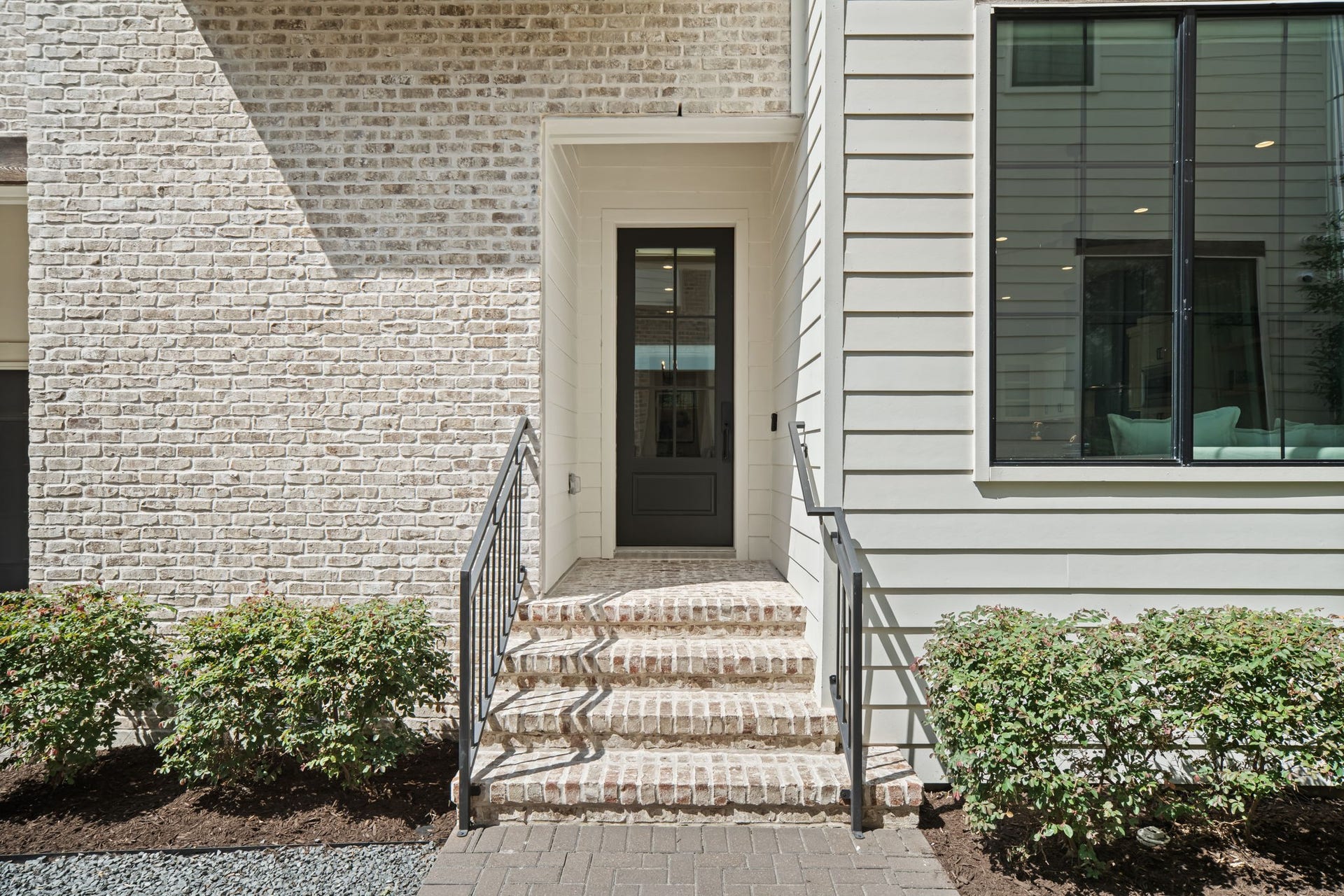 733 E 10th 1/2 Street, Houston, TX 77008 Covered entry and handsome black-framed door welcome guests into the home. Brick steps and streamlined metal railings complement the contemporary exterior.