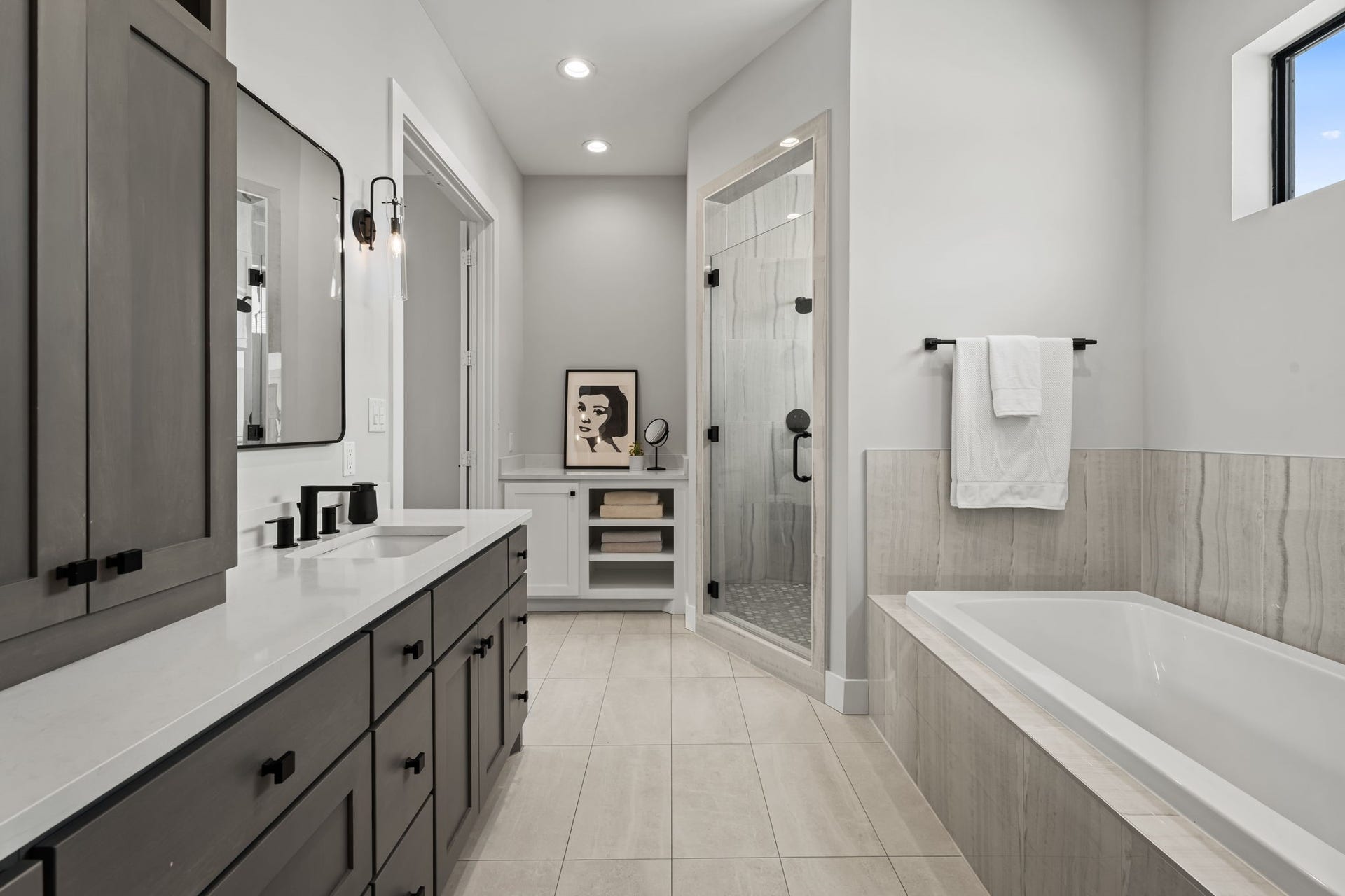 733 E 10th 1/2 Street, Houston, TX 77008 A deep soaking tub and extensive quartz-topped vanity bring a spa-inspired quality to the primary bath. Layered lighting and streamlined cabinetry complete the serene design.