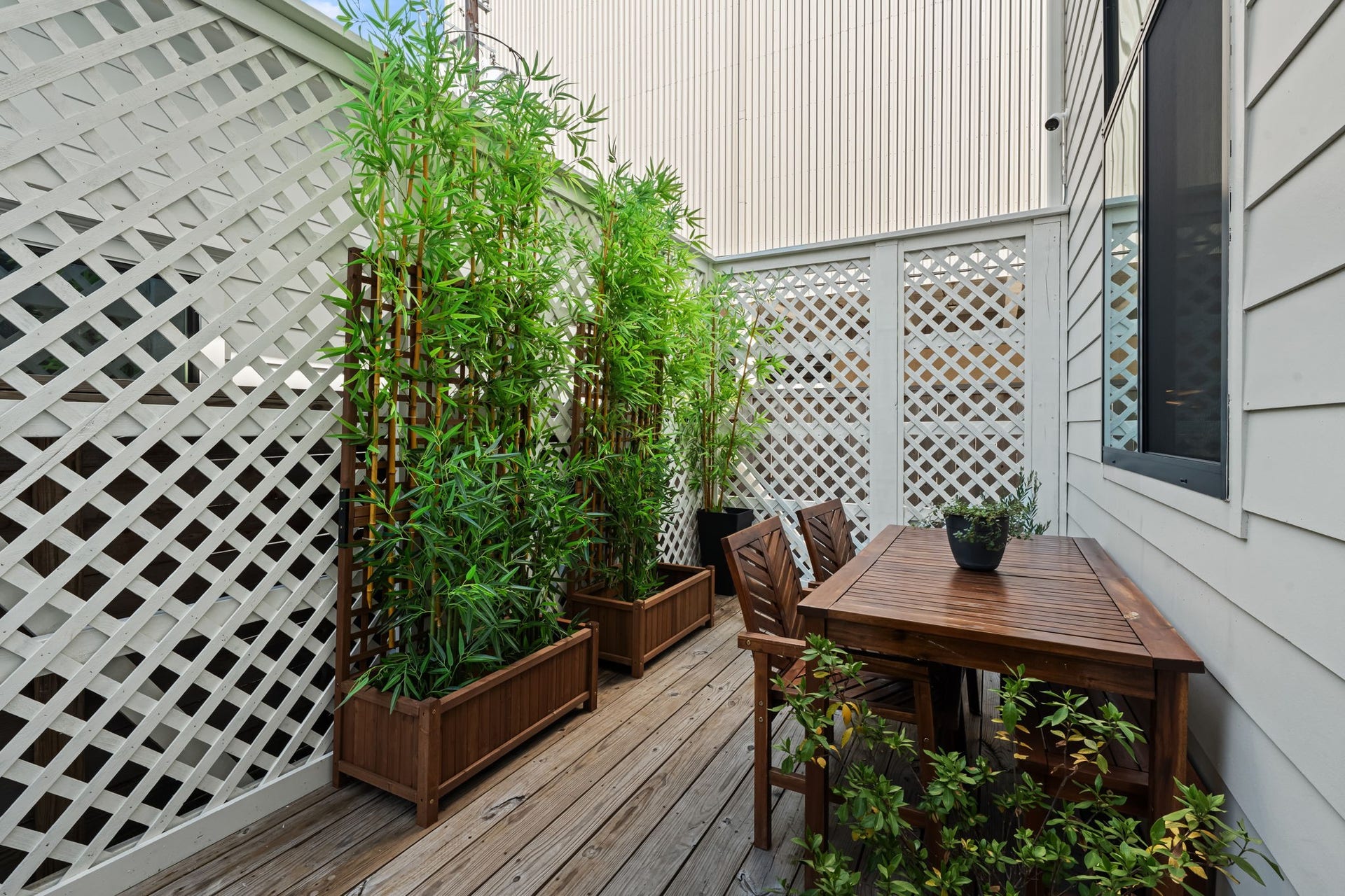 733 E 10th 1/2 Street, Houston, TX 77008 A secluded rear deck creates an intimate setting for open-air dining and relaxation. Lattice screening and mature greenery enhance the sense of privacy.