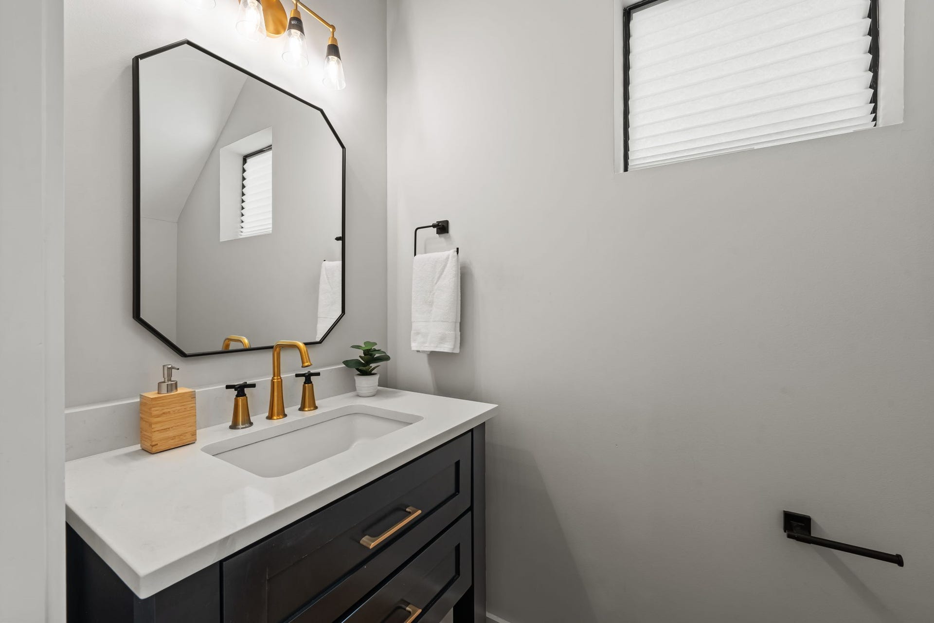 733 E 10th 1/2 Street, Houston, TX 77008 A streamlined vanity and contemporary lighting create a polished first-floor powder bath. The compact design makes efficient use of space without sacrificing style.