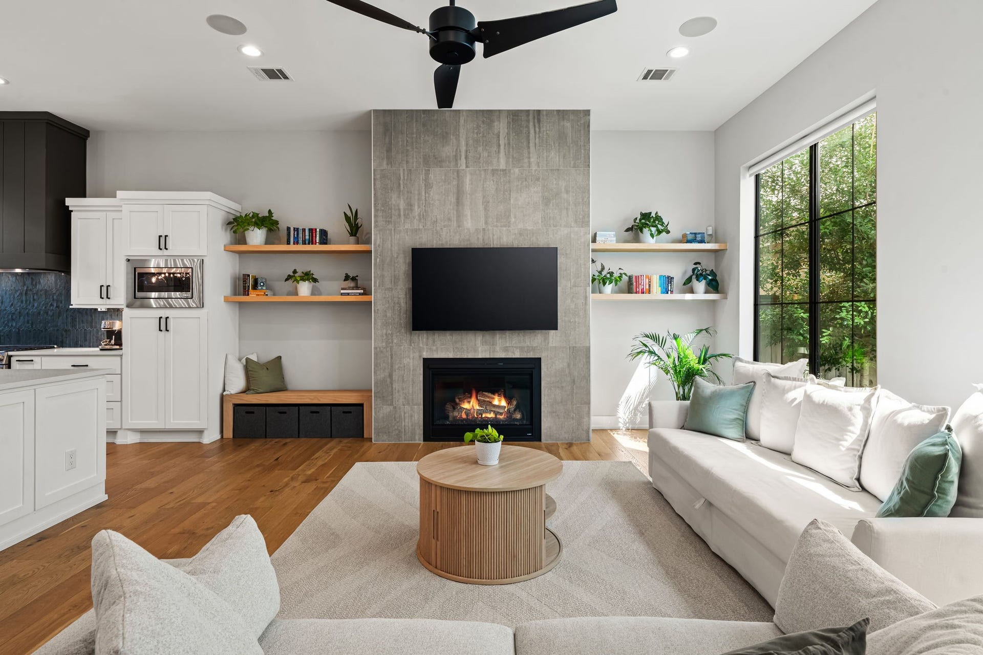 733 E 10th 1/2 Street, Houston, TX 77008 Expansive black-framed windows bring leafy views and abundant daylight into the living area. Open shelving and a streamlined fireplace wall add warmth and architectural character.