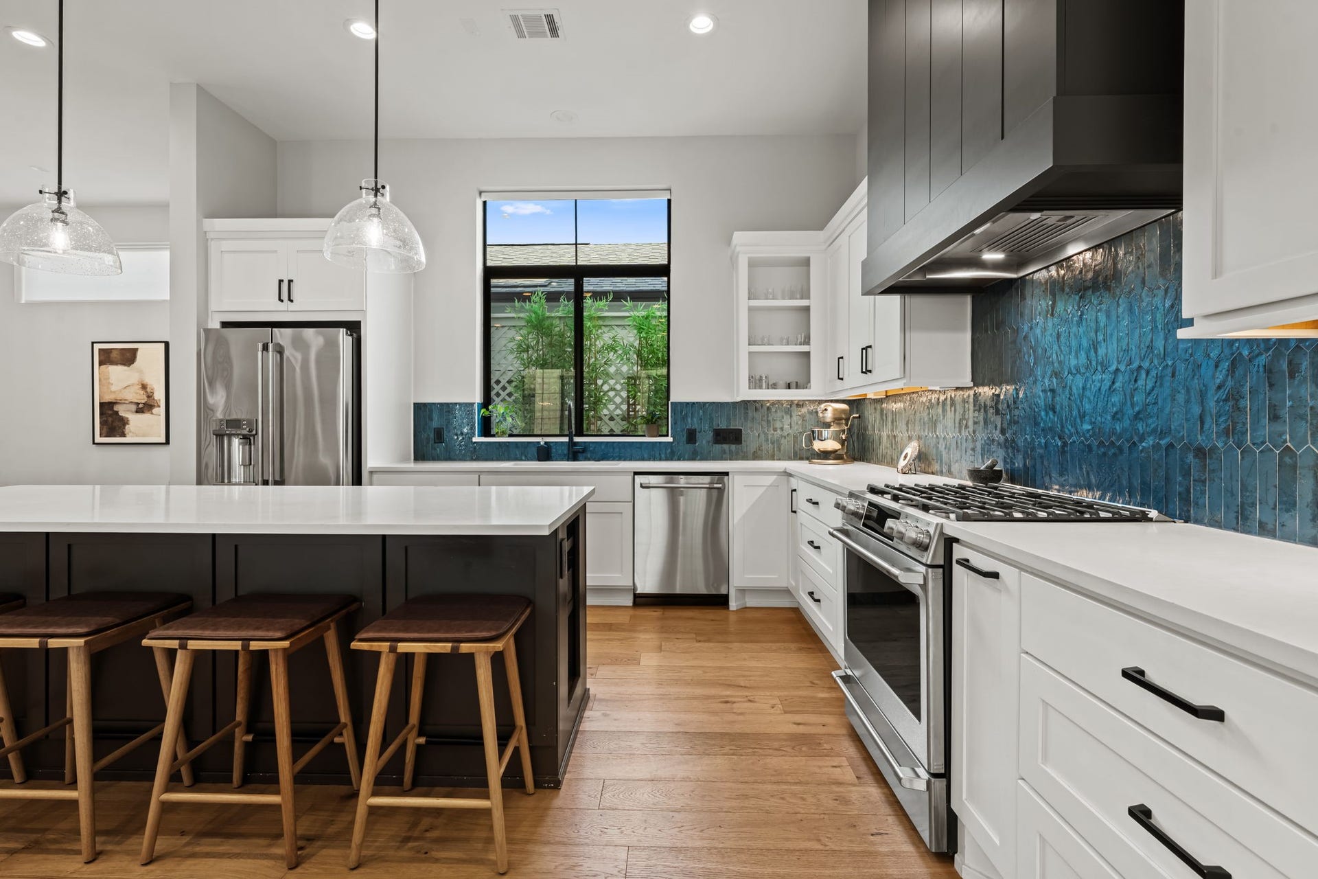 733 E 10th 1/2 Street, Houston, TX 77008 The designer kitchen showcases white shaker cabinetry, quartz countertops, and a rich Moroccan-blue tile backsplash. GE Cafe appliances and under-cabinet lighting balance polished style with everyday function.