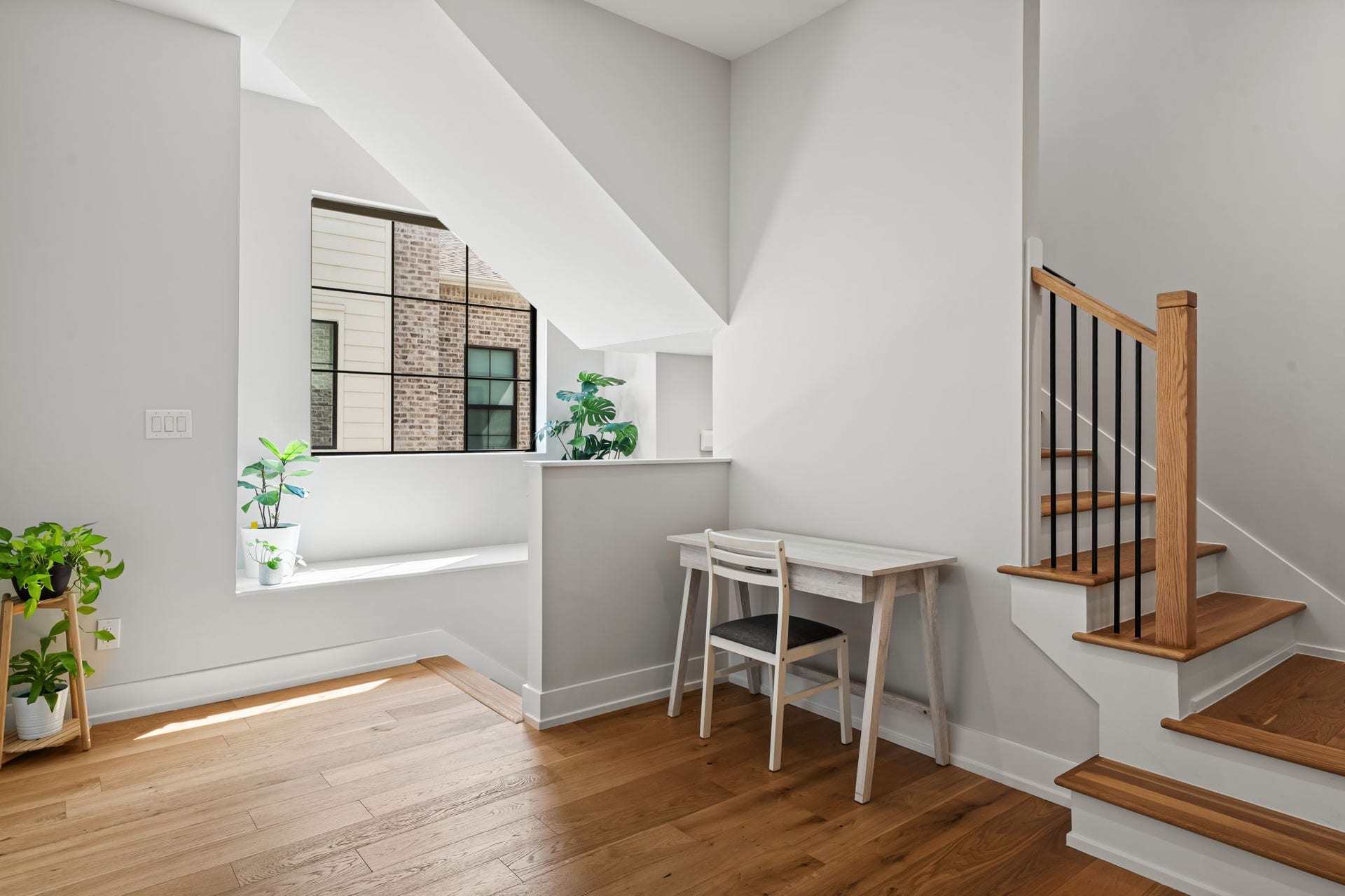 733 E 10th 1/2 Street, Houston, TX 77008 A sunlit landing provides a versatile niche for working, reading, or creative pursuits. A dramatic black-framed window and white oak flooring continue the home's cohesive design.