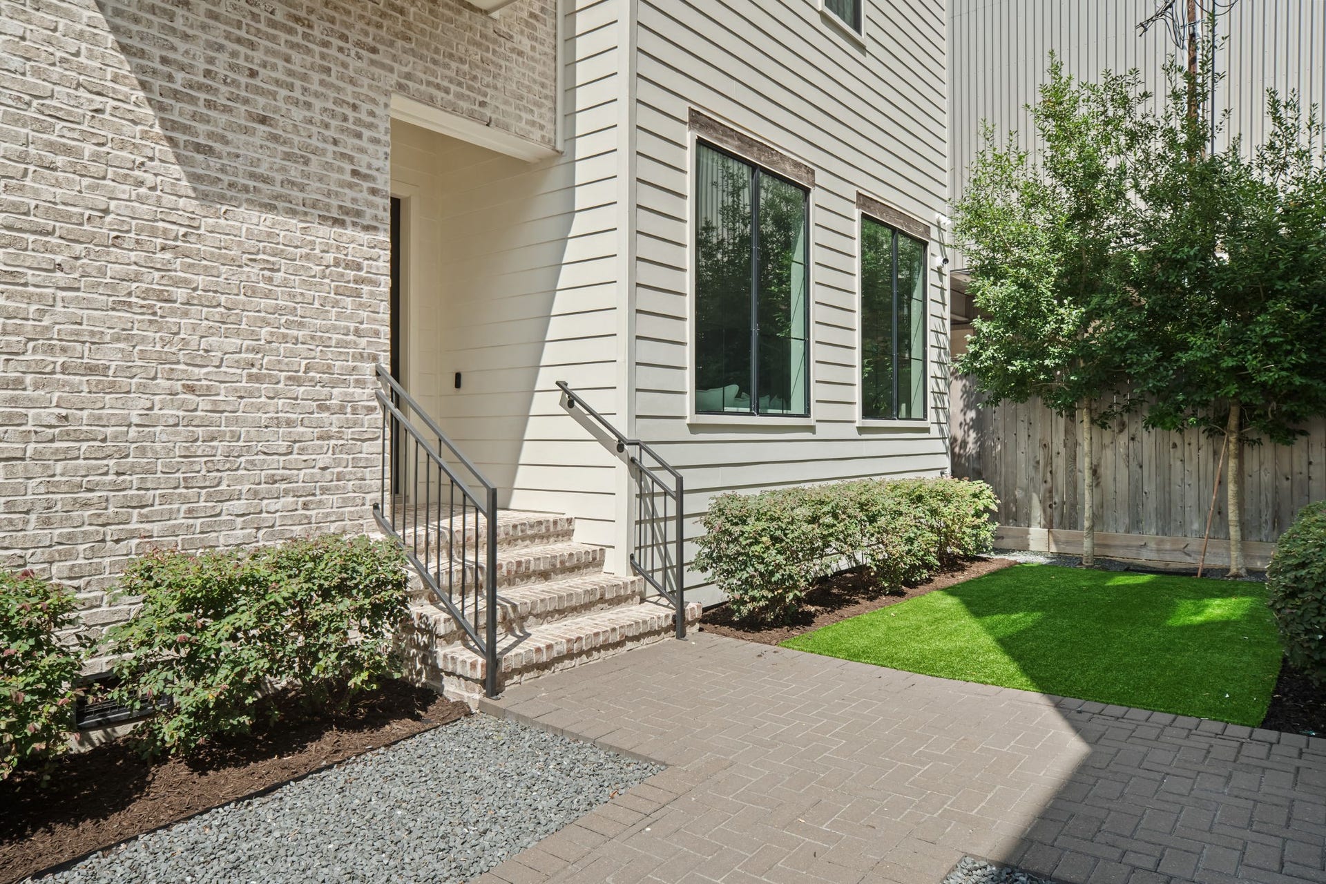 733 E 10th 1/2 Street, Houston, TX 77008 Manicured plantings and low-maintenance artificial turf frame the approach to the residence. The exterior's warm masonry and crisp architectural lines establish a polished sense of arrival.