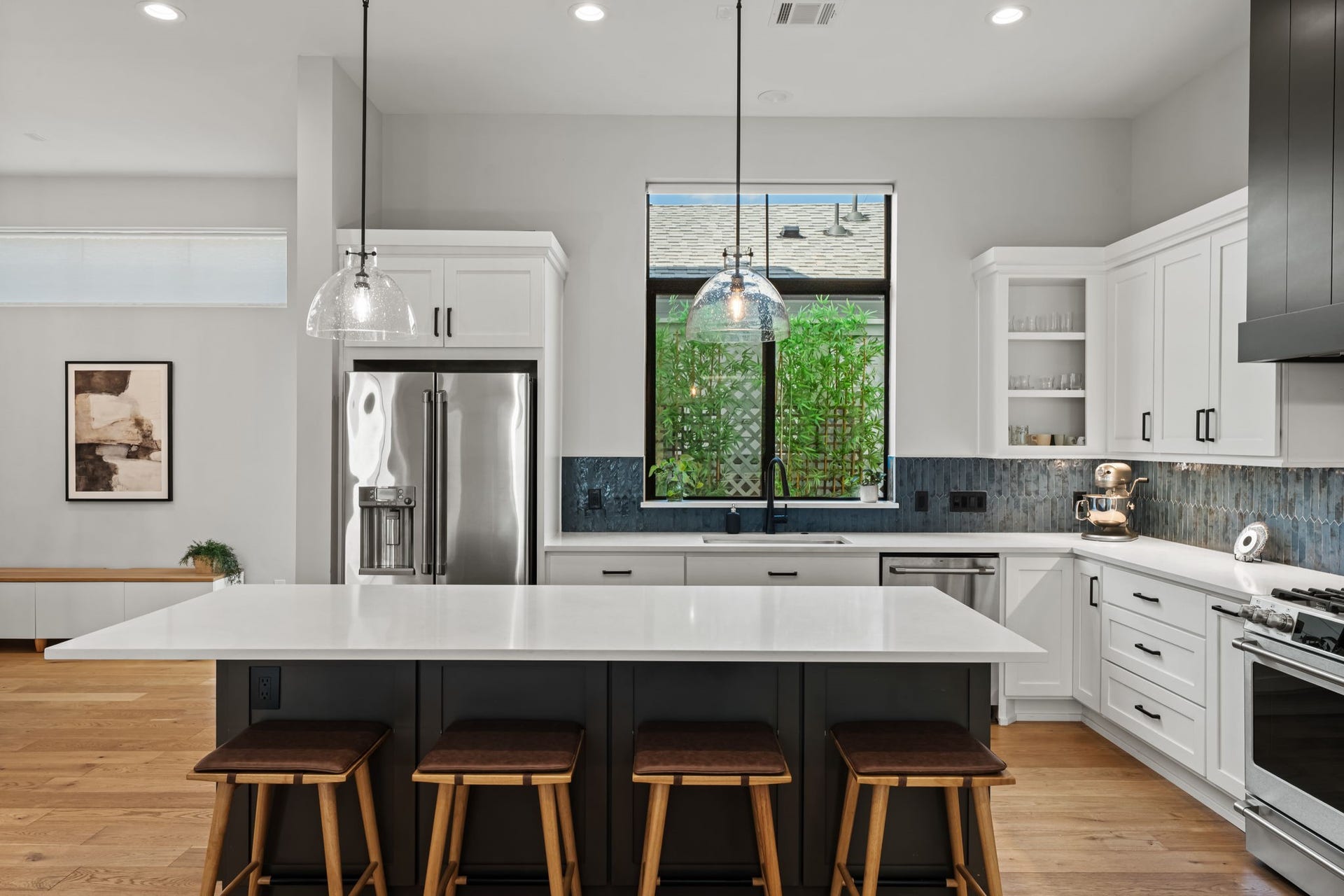 733 E 10th 1/2 Street, Houston, TX 77008 The kitchen's generous workspace continues beneath a large window overlooking greenery. Quartz surfaces, abundant cabinetry, and a stainless-steel sink support an efficient everyday routine.