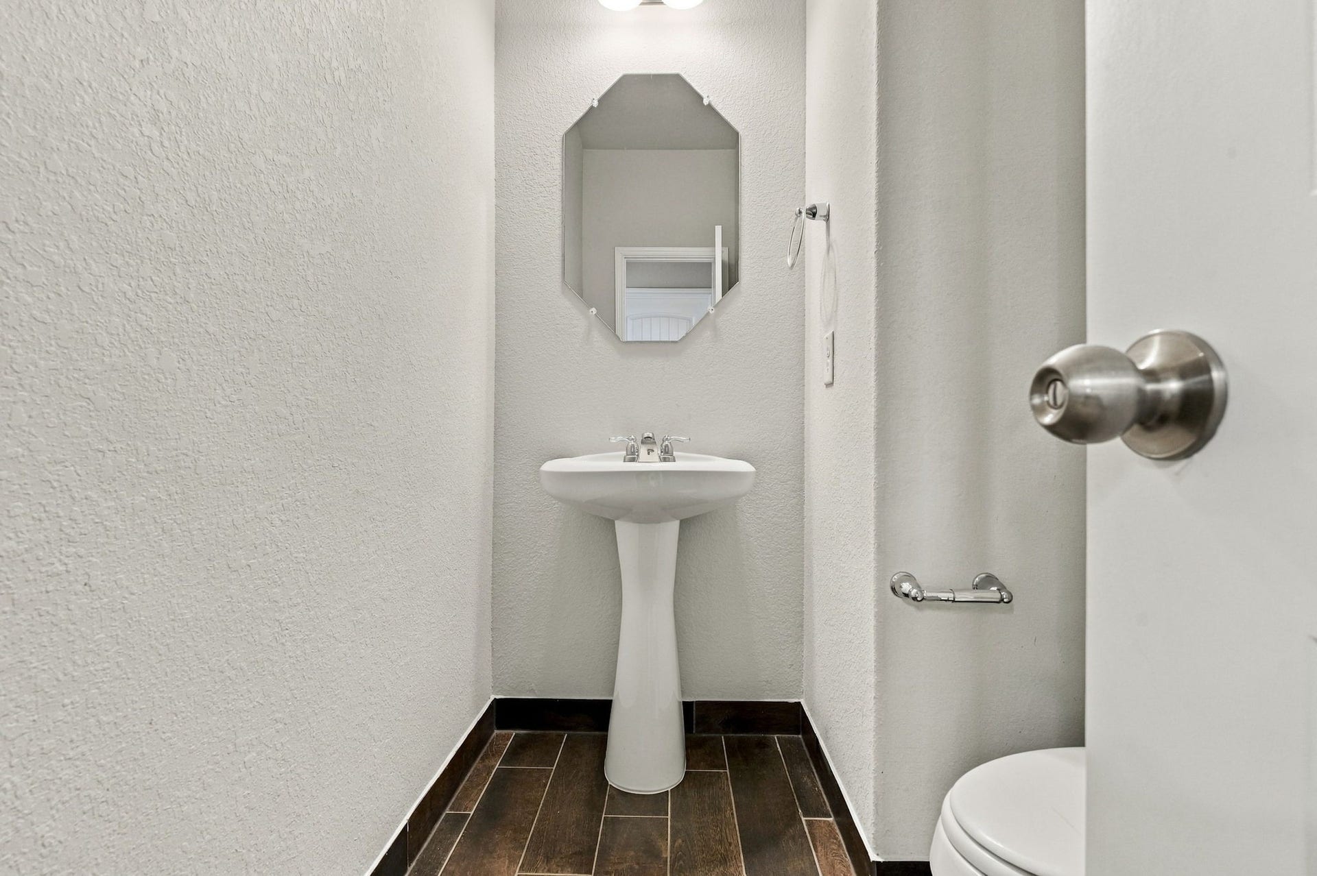 24115 Lake Molveno Drive, Katy, TX 77493 Designed with smart spatial efficiency, this guest powder room combines timeless fixtures with low-maintenance flooring.
