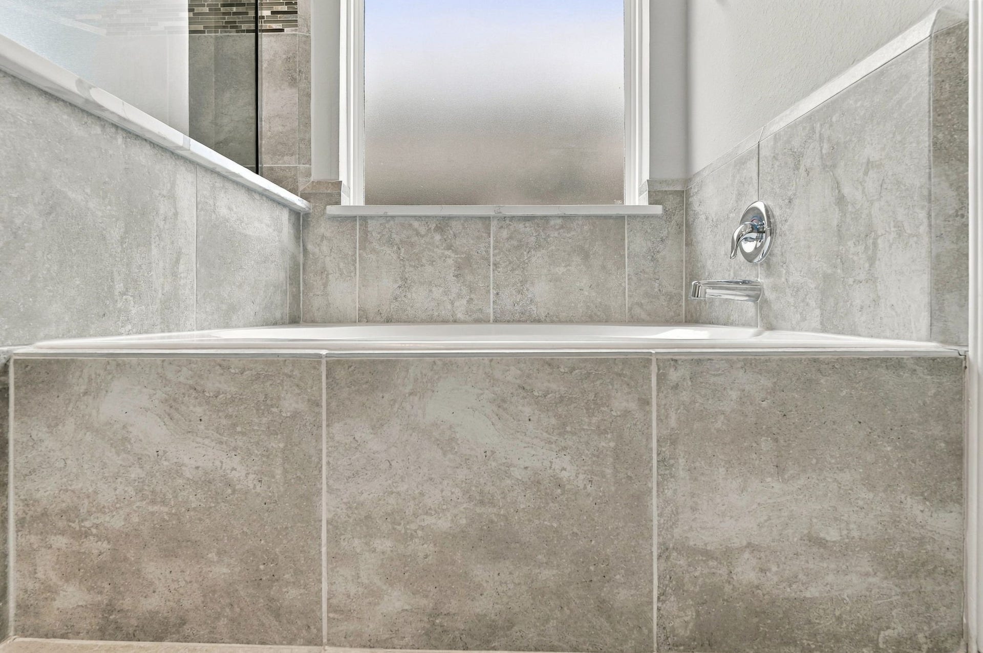24115 Lake Molveno Drive, Katy, TX 77493 Designed as a tranquil focal point, this deep garden tub features custom tile surrounding all sides for an elevated presentation.