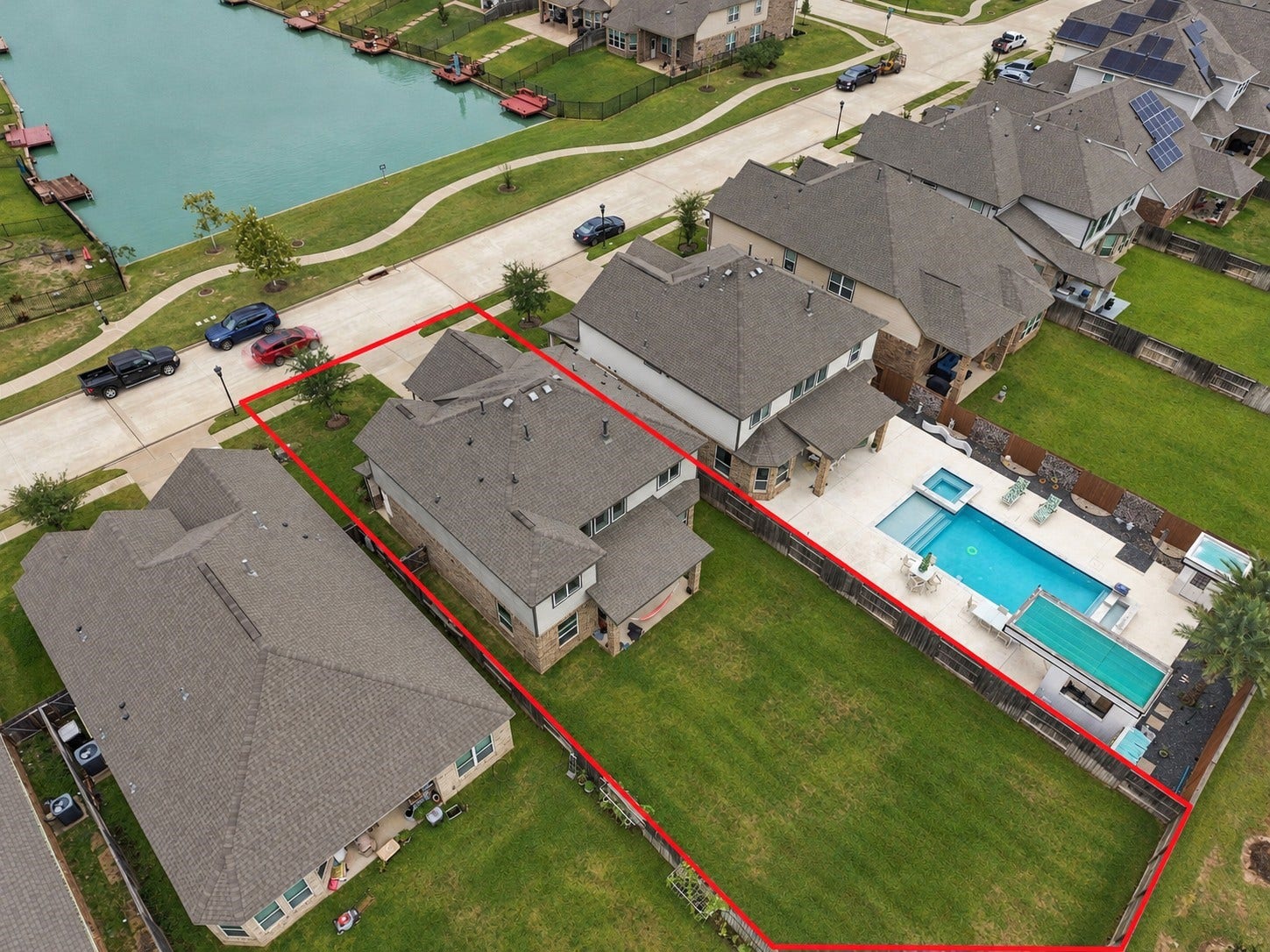24115 Lake Molveno Drive, Katy, TX 77493 This elevated drone shot emphasizes the home's premier location within a quiet residential community just across from a scenic neighborhood lake. Featuring a wide concrete driveway and a multi-story roofline, the property balances prime neighborhood positioning with generous private land.
