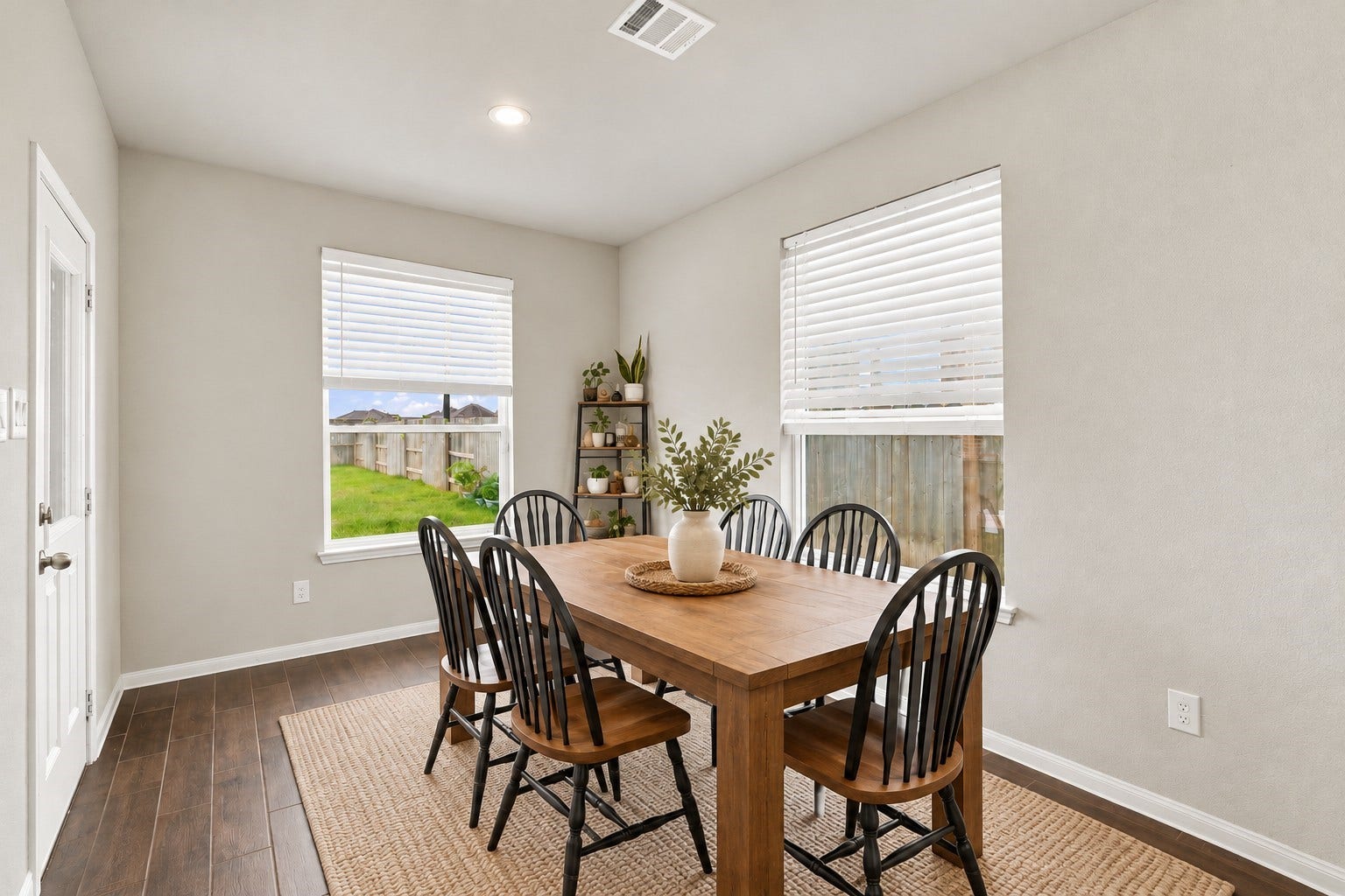 24115 Lake Molveno Drive, Katy, TX 77493 Virtually Staged: This sunlit dining alcove offers a bright, dedicated space for family meals and casual entertaining. Large dual-aspect windows with fitted blinds overlook the lush green backyard, filling the area with natural daylight.