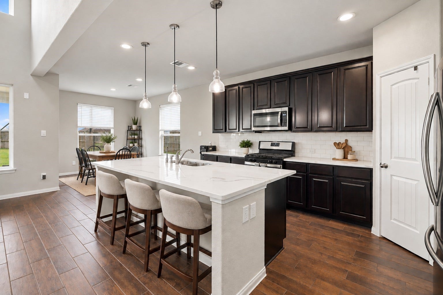 24115 Lake Molveno Drive, Katy, TX 77493 Virtually Staged: This beautifully designed chefs kitchen centers around an expansive island featuring durable quartz countertops, an integrated undermount sink, and comfortable breakfast bar seating.