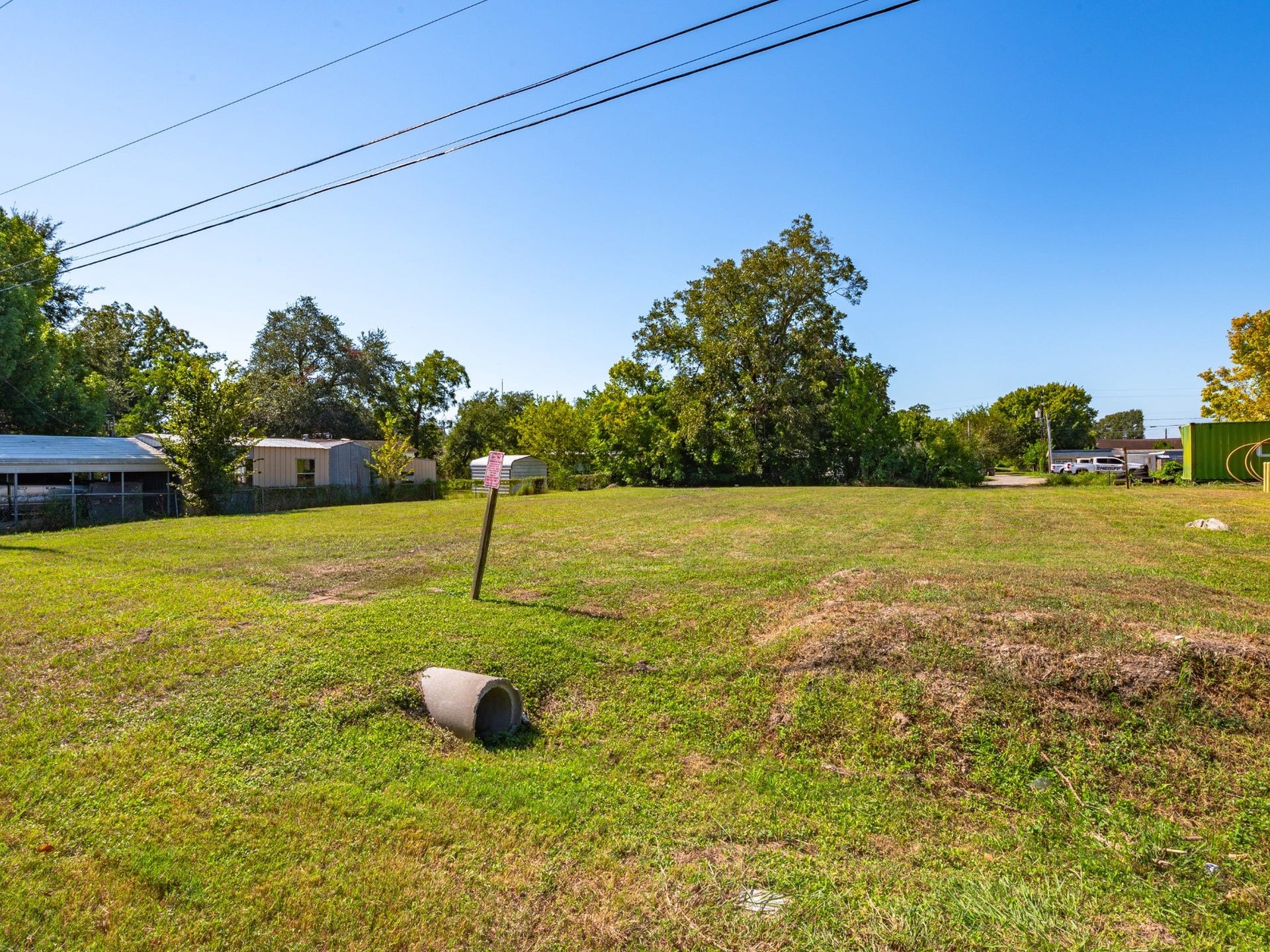4618 11th Street, Bacliff, TX 77518 Ground-level view across the grassy lot toward the rear tree line.