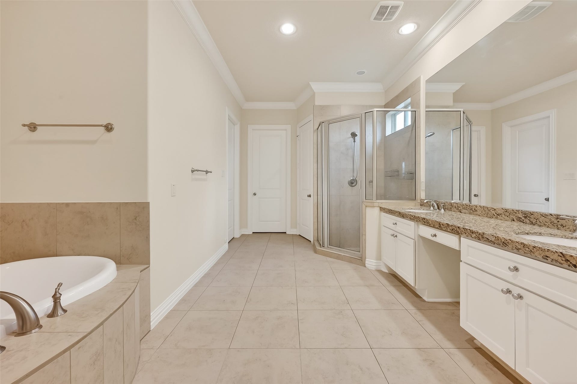 14447 KINGSTON COVE Lane, Houston, TX 77077 Primary bathroom offers two separate master closets, standing shower with clear enclosure, double vanities and an expansive wall mirror.