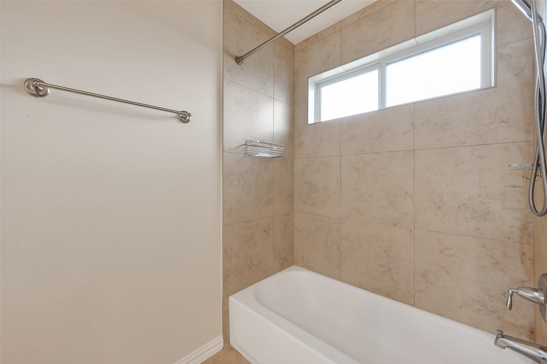 14447 KINGSTON COVE Lane, Houston, TX 77077 This shared bathroom offers a tub, tiled walls and clerestory windows that allow natural light in.